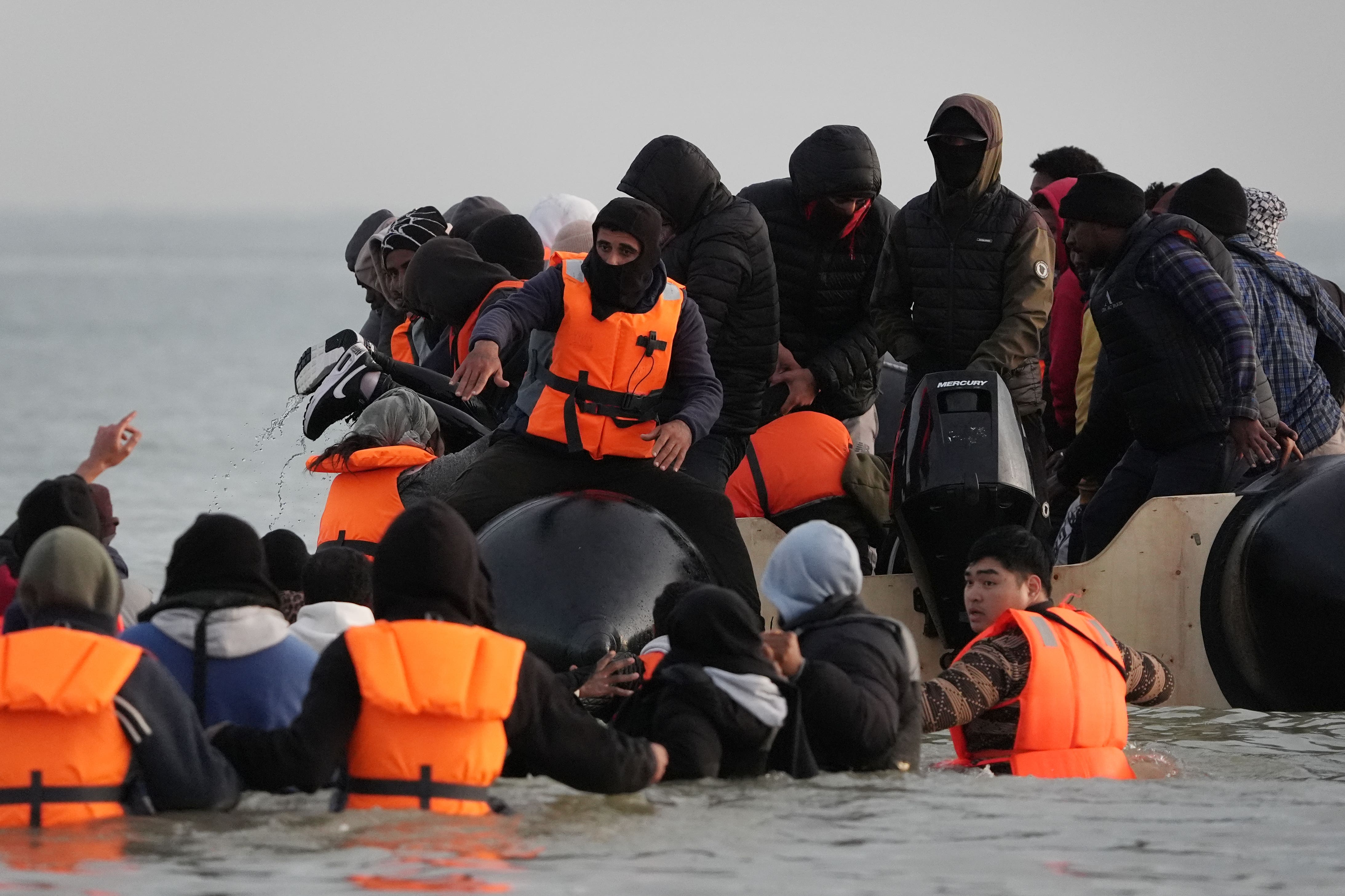 People wade through the sea to board a small boat leaving the beach at Gravelines, France, earlier this month