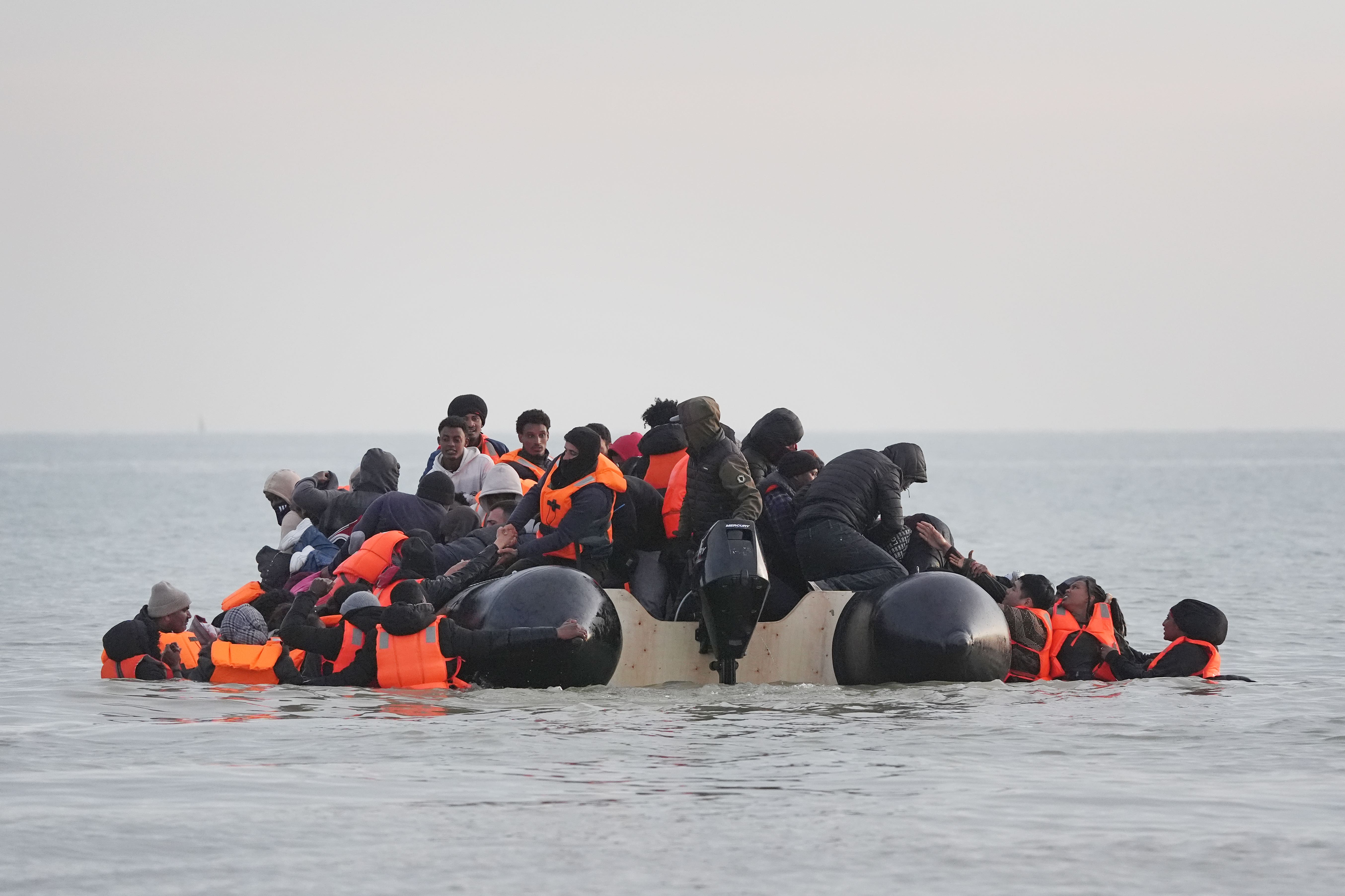 People thought to be migrants scramble onboard a small boat leaving the beach at Gravelines, France (Gareth Fuller/PA)