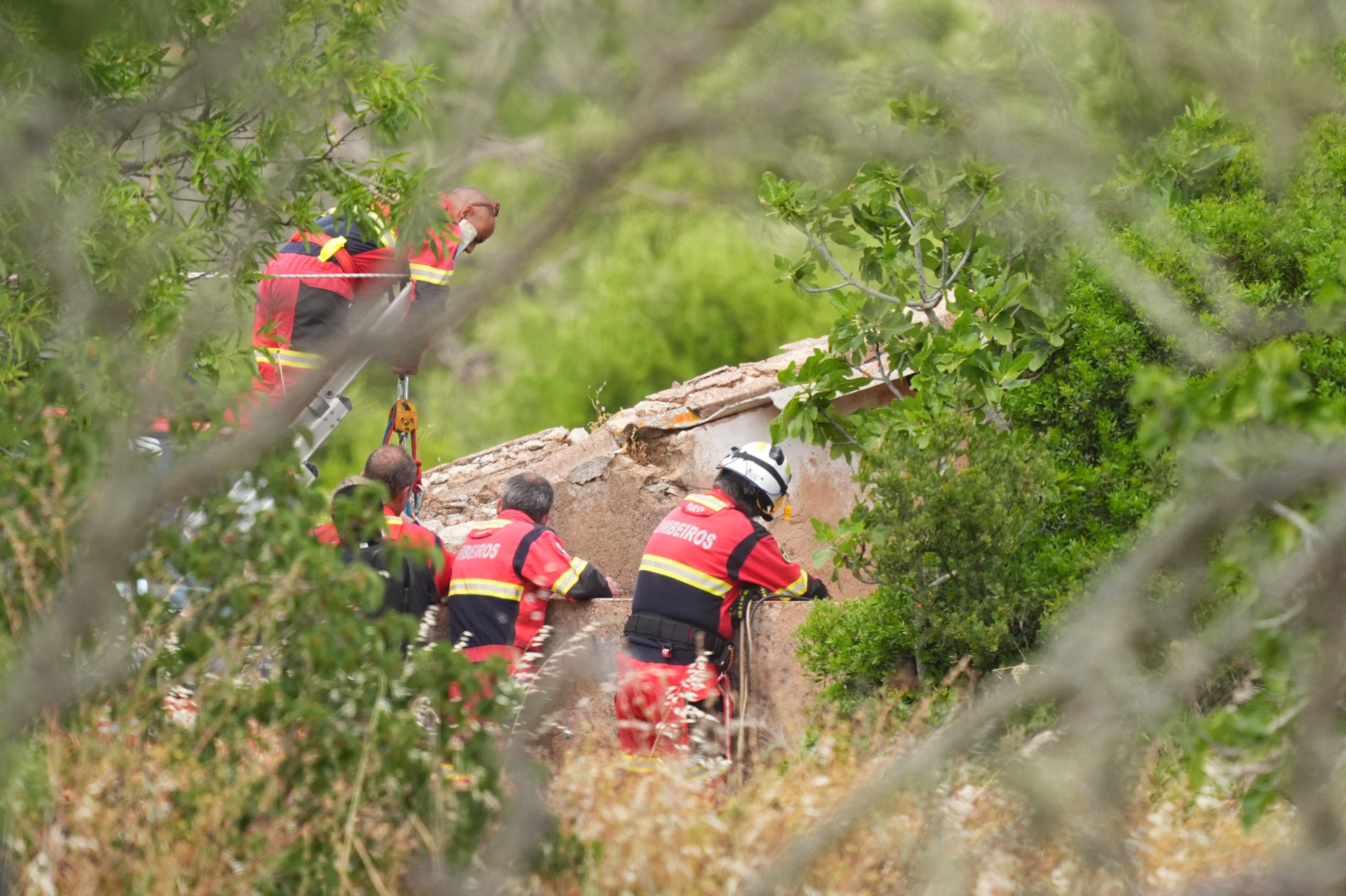Firefighters and search teams check a well during the search on Tuesday