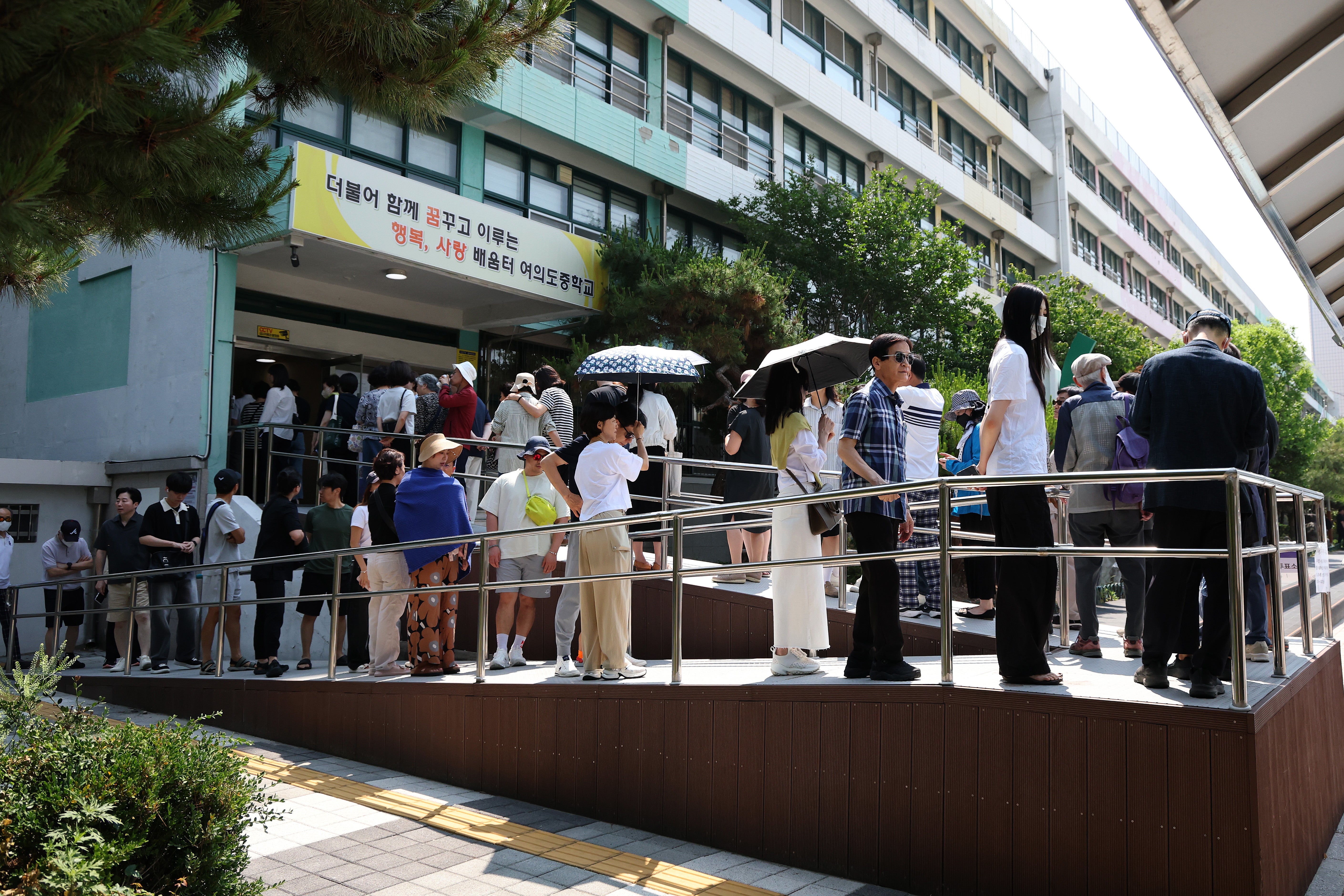 People wait in line to cast their votes in South Korea’s presidential election on 3 June 2025