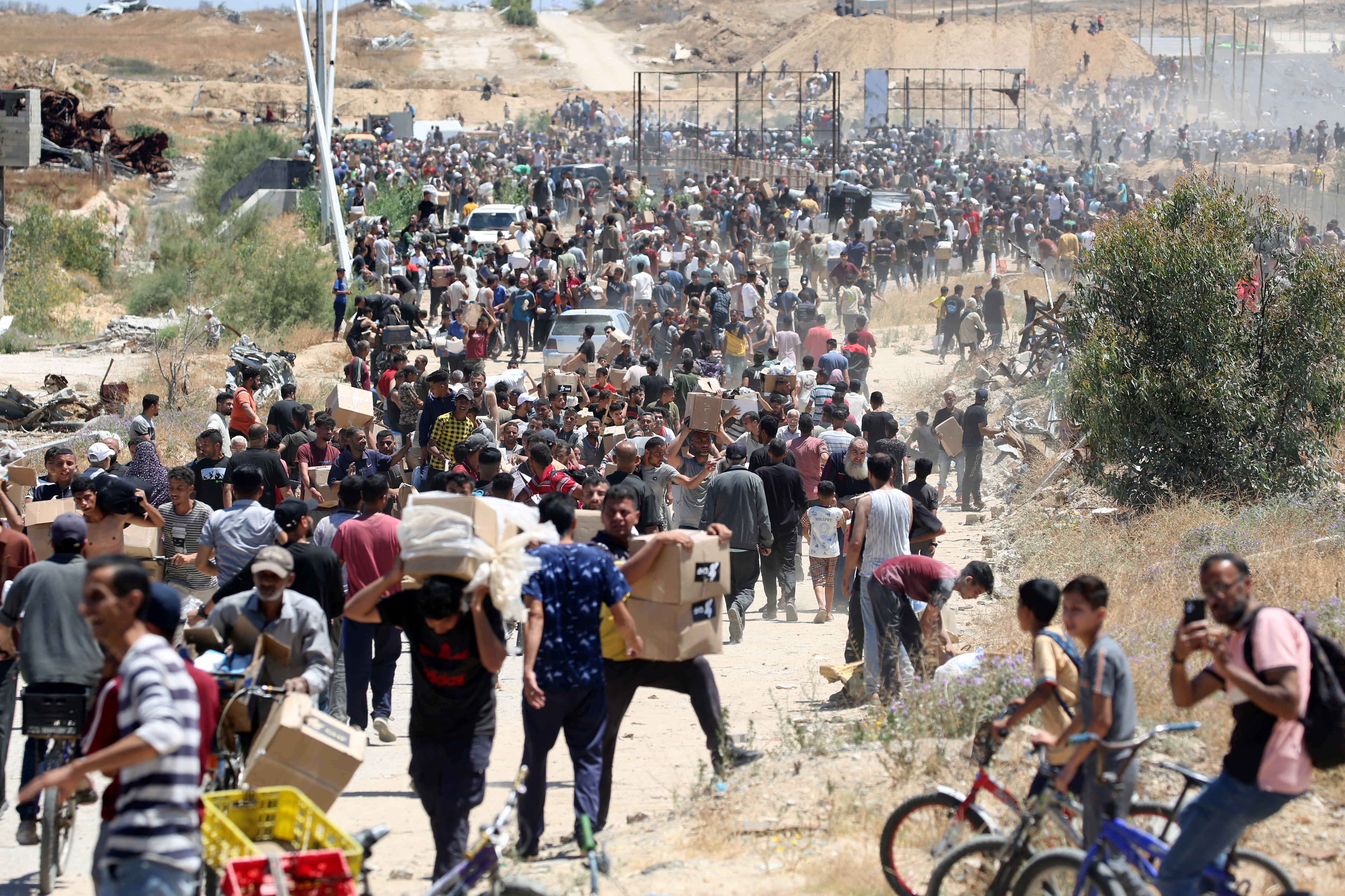 People carry boxes of relief supplies from the Gaza Humanitarian Foundation