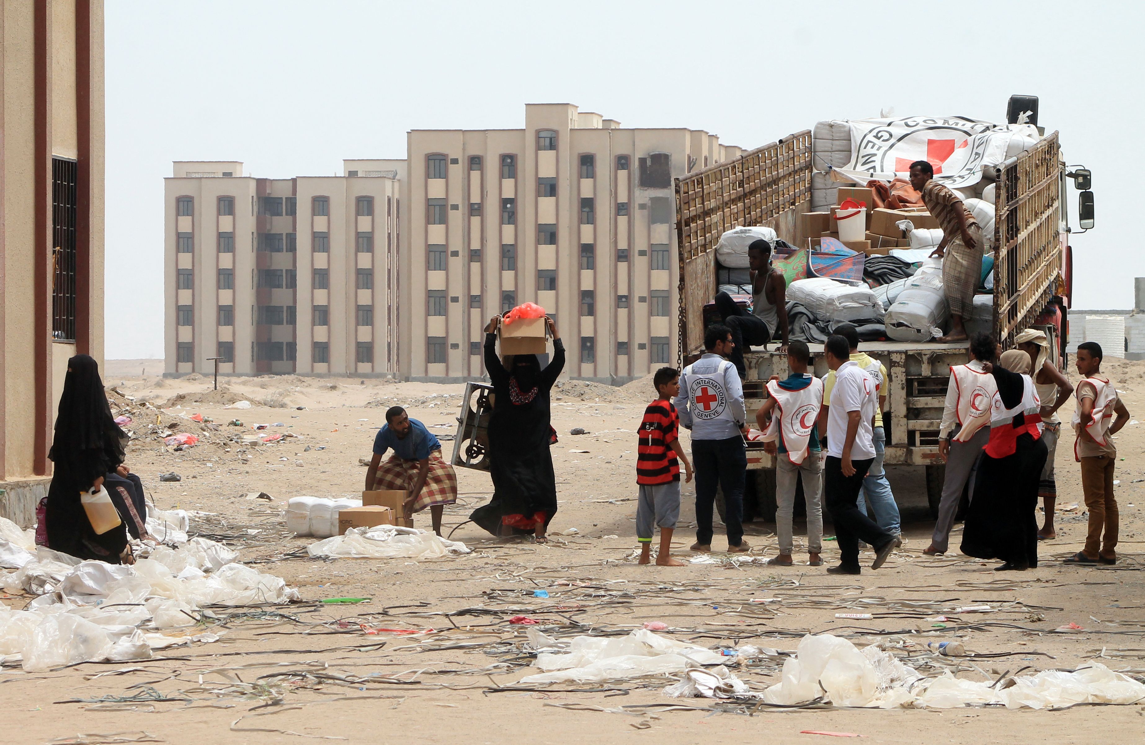 Members of the Yemeni Red Crescent Society distribute aid to displaced families in Aden