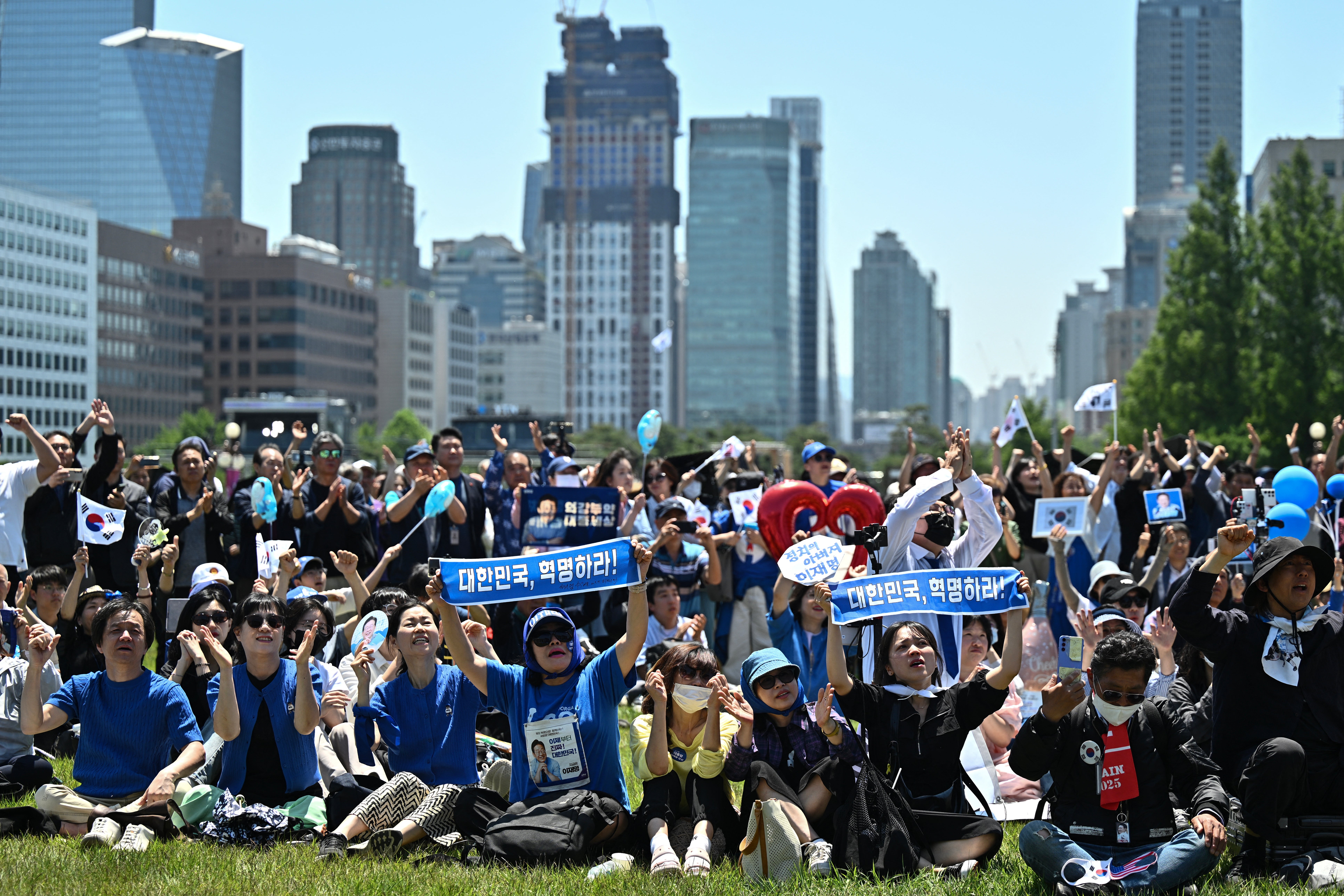 People cheer as they watch the inauguration ceremony of South Korea's President Lee Jae Myung outside the National Assembly in Seoul on 4 June 2025