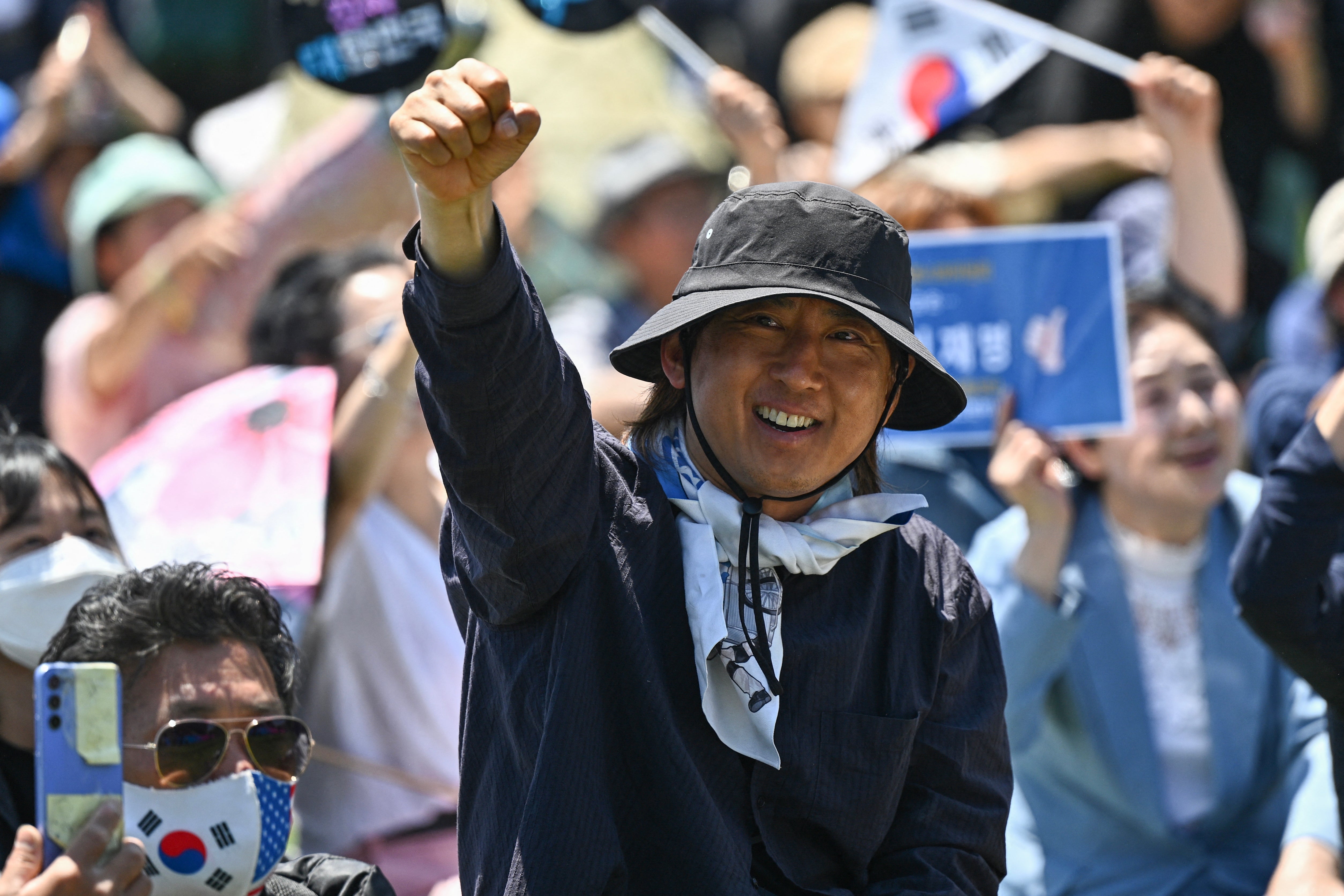 People cheer as they watch the inauguration ceremony of South Korea's president Lee Jae Myung outside the National Assembly in Seoul on 4 June 2025