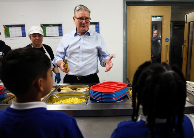 <p>Keir Starmer serves lunch duiring a visit to a school in Harlow, Essex, on Thursday</p>