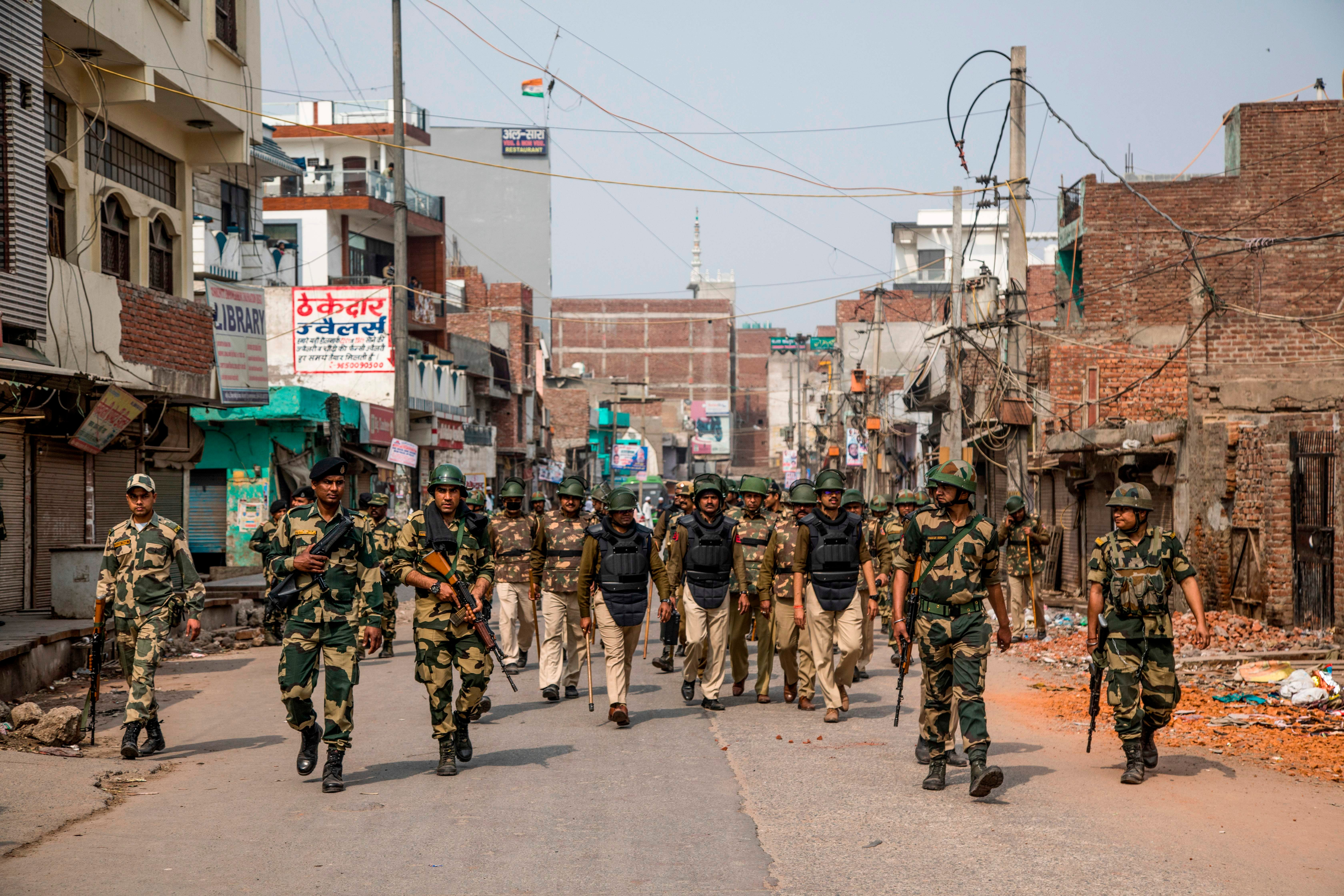 File. Security personnel patrol a street following sectarian riots in Delhi on 28 February 2020