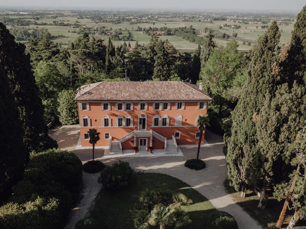 The elegant Relais Roncolo 1888 hotel awaits at the end of a long, winding gravel drive lined with tall cypress trees and pines