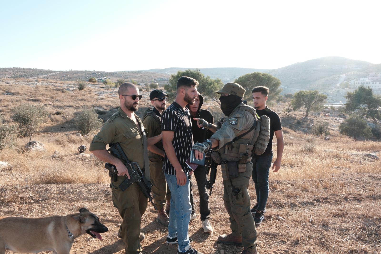 Mohammad Hesham Huraini (right) and his cousin Mohammad Hureini (centre) are apprehended by Israeli troops in Masafer Yatta