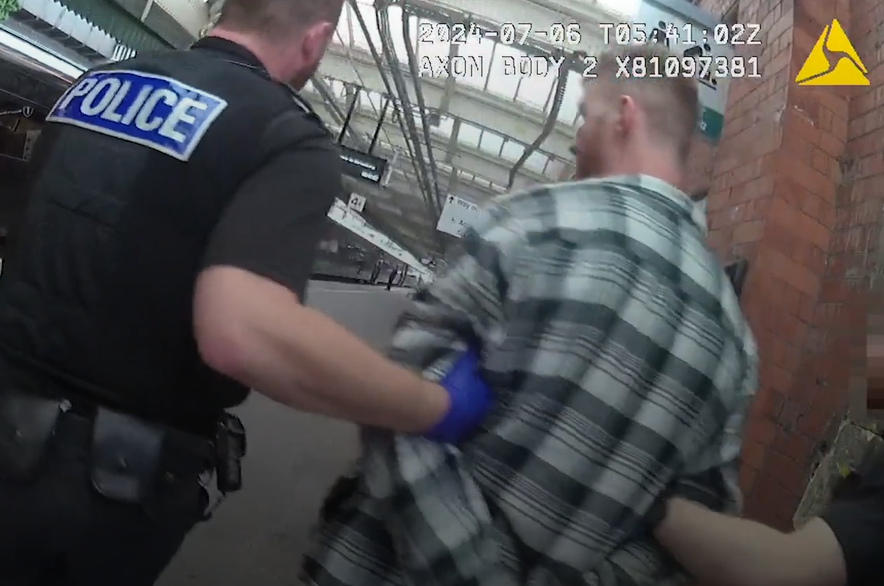 John Harvey being led away along a platform by police (West Mercia Police/PA)