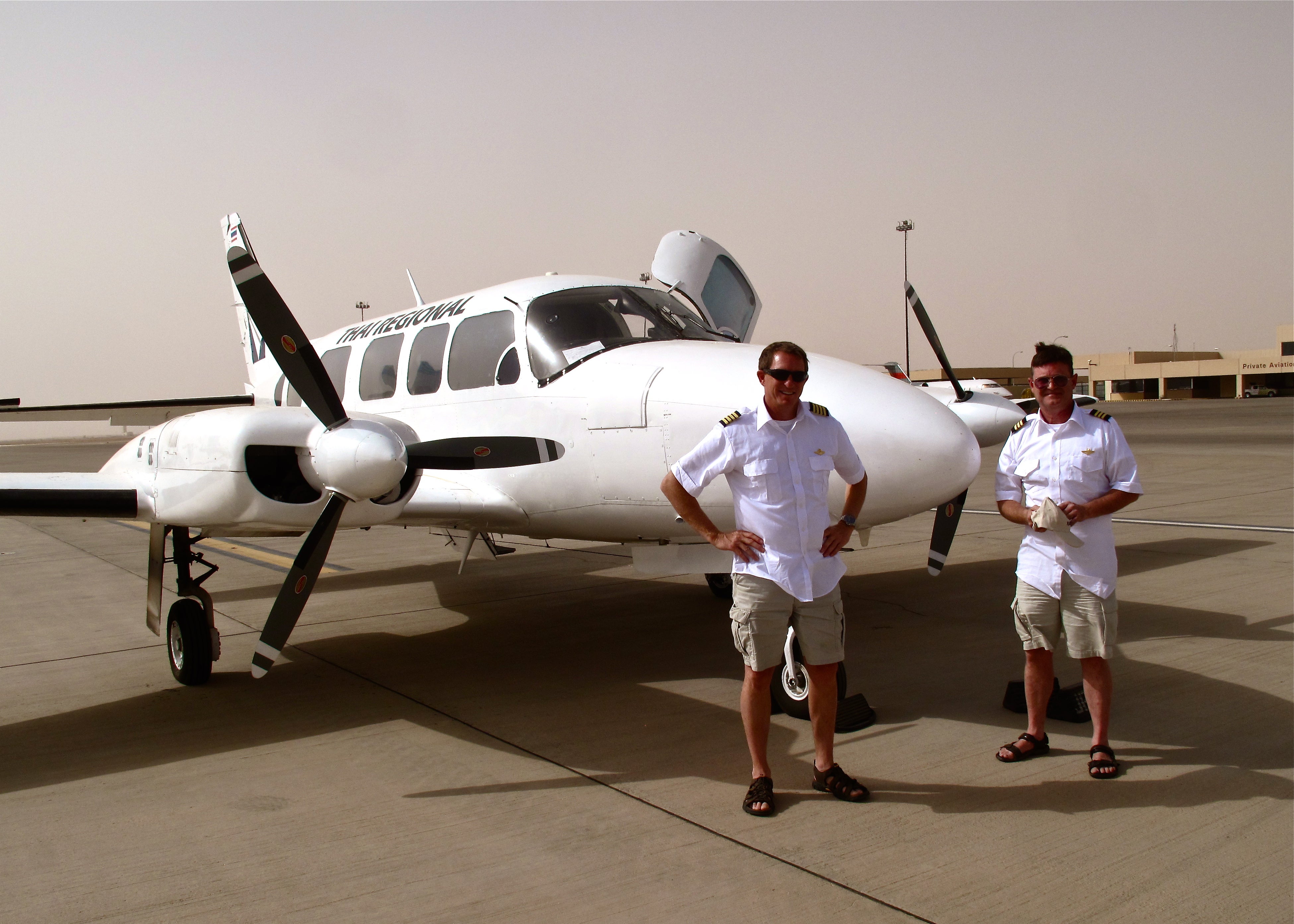 Kerry (left) is pictured here with a Piper Navajo that he was supposed to fly from Florida to Bangkok in 2014 with his best friend, Lee Wolfgram (right). But they had 'multiple in-flight emergencies' and had to abandon the plane in Oman. The picture here was taken in Saudi Arabia