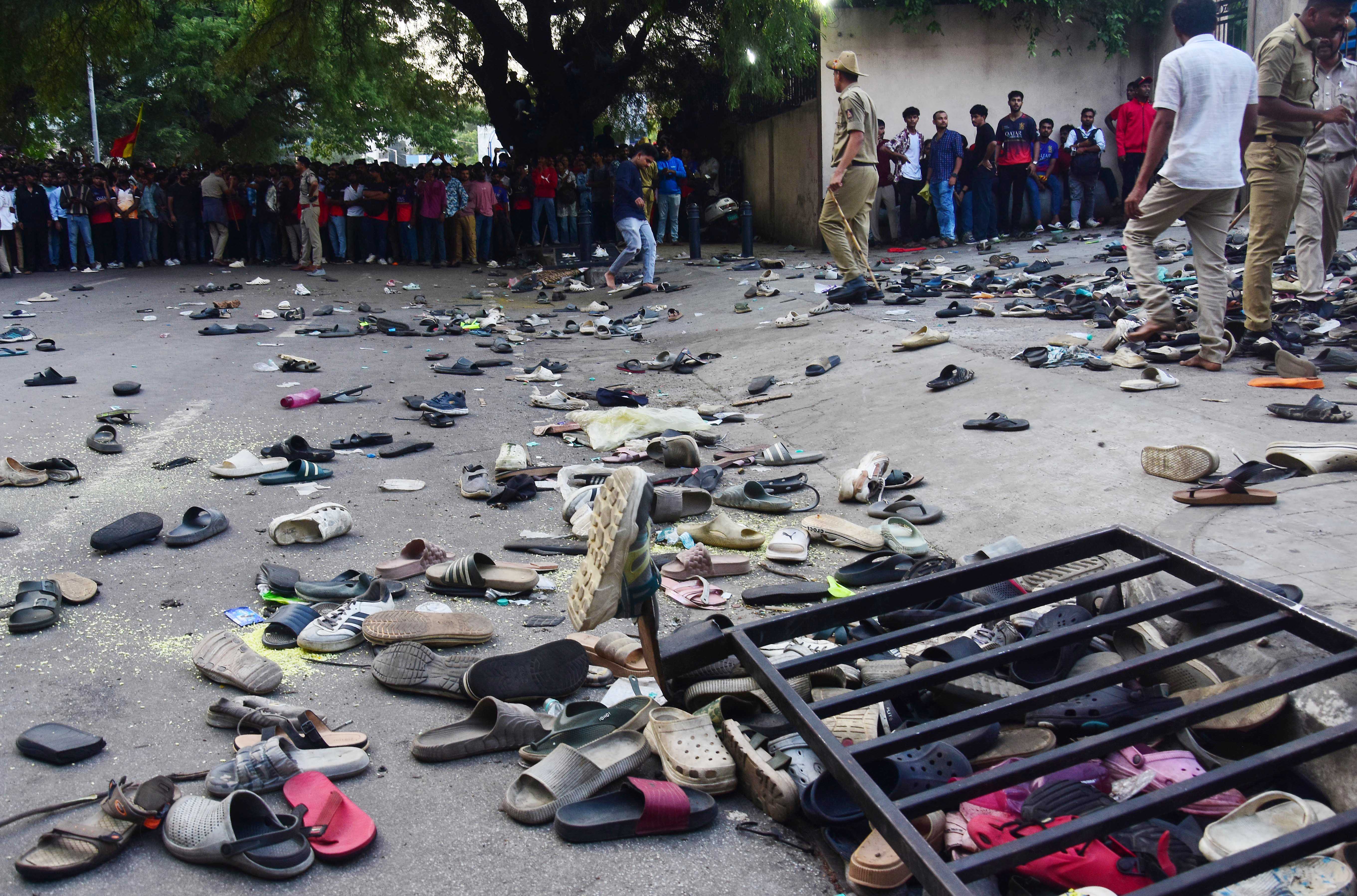 Fans stand next to abandonned shoes and a fallen barrier following a stampede during celebrations, a day after Royal Challengers Bengaluru's victory at the Indian Premier League (IPL) Twenty20 final cricket match, outside the M. Chinnaswamy Stadium in Bengaluru