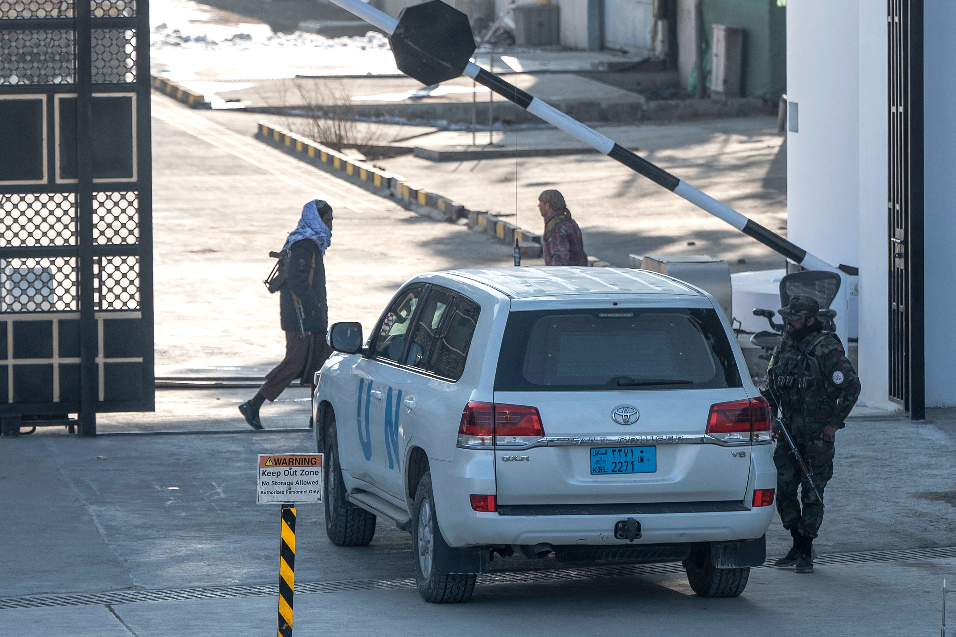 Taliban security personnel check a UN vehicle at a newly built gate in Kabul