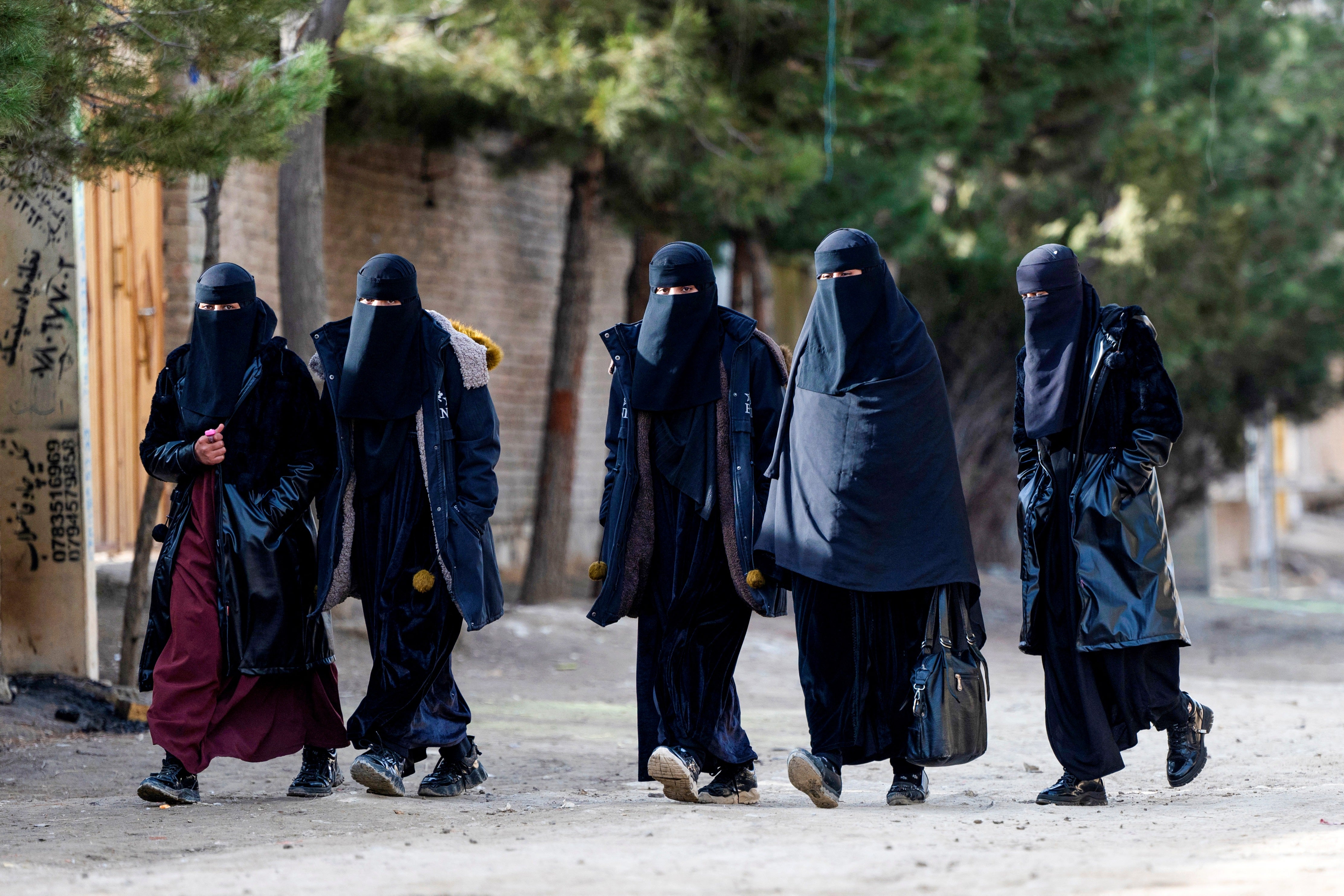Afghan women walk along a street on the outskirts of Kabul