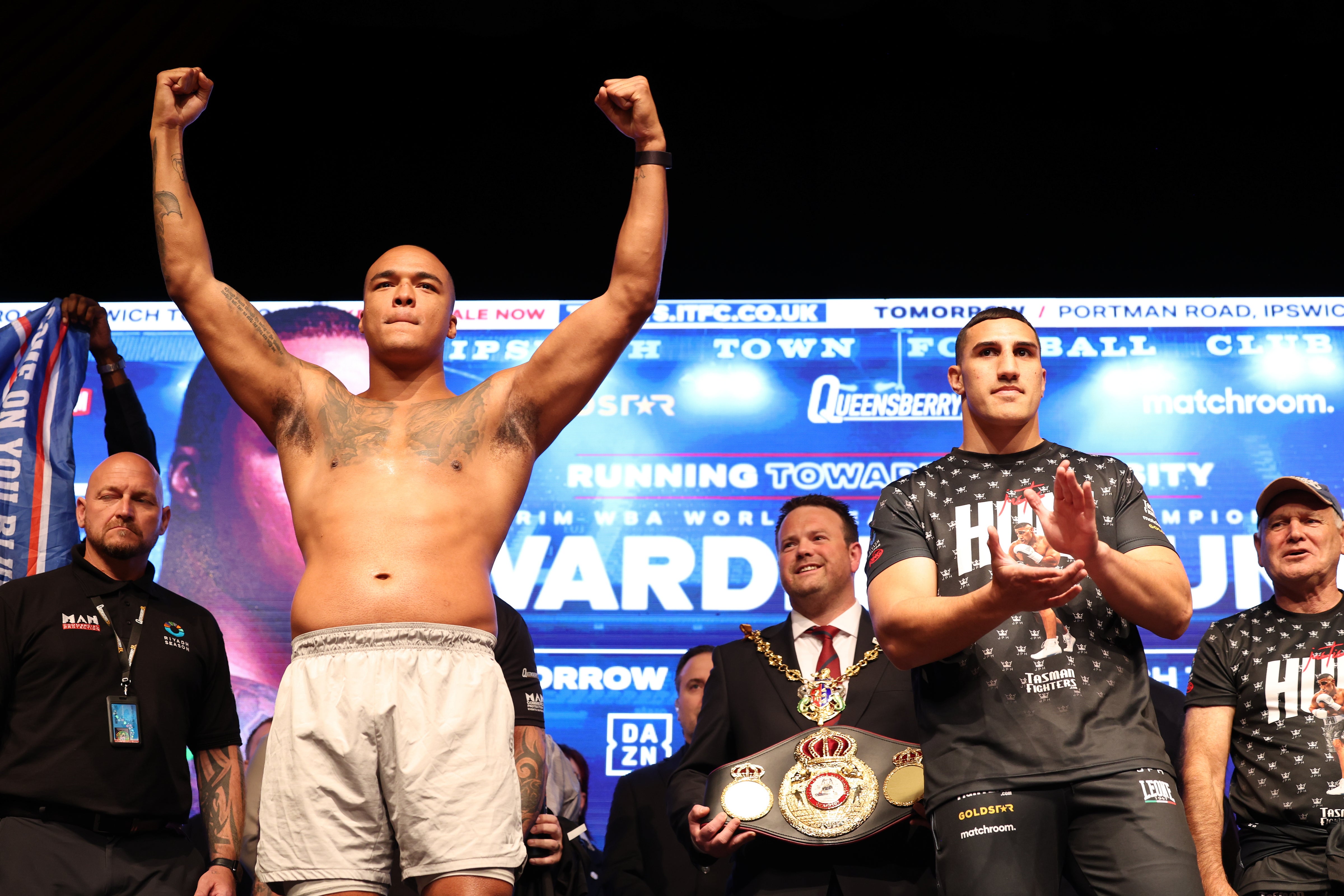 Fabio Wardley (L) stands arms aloft during the weigh-in for his bout with Justis Huni (R) on Saturday, June 7, for the WBA interim heavyweight title