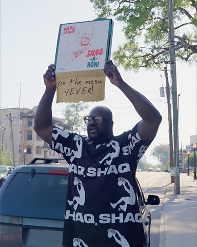 A photo of Shaquille O’Neal holding a box of his Shaq-a-Roni pizza