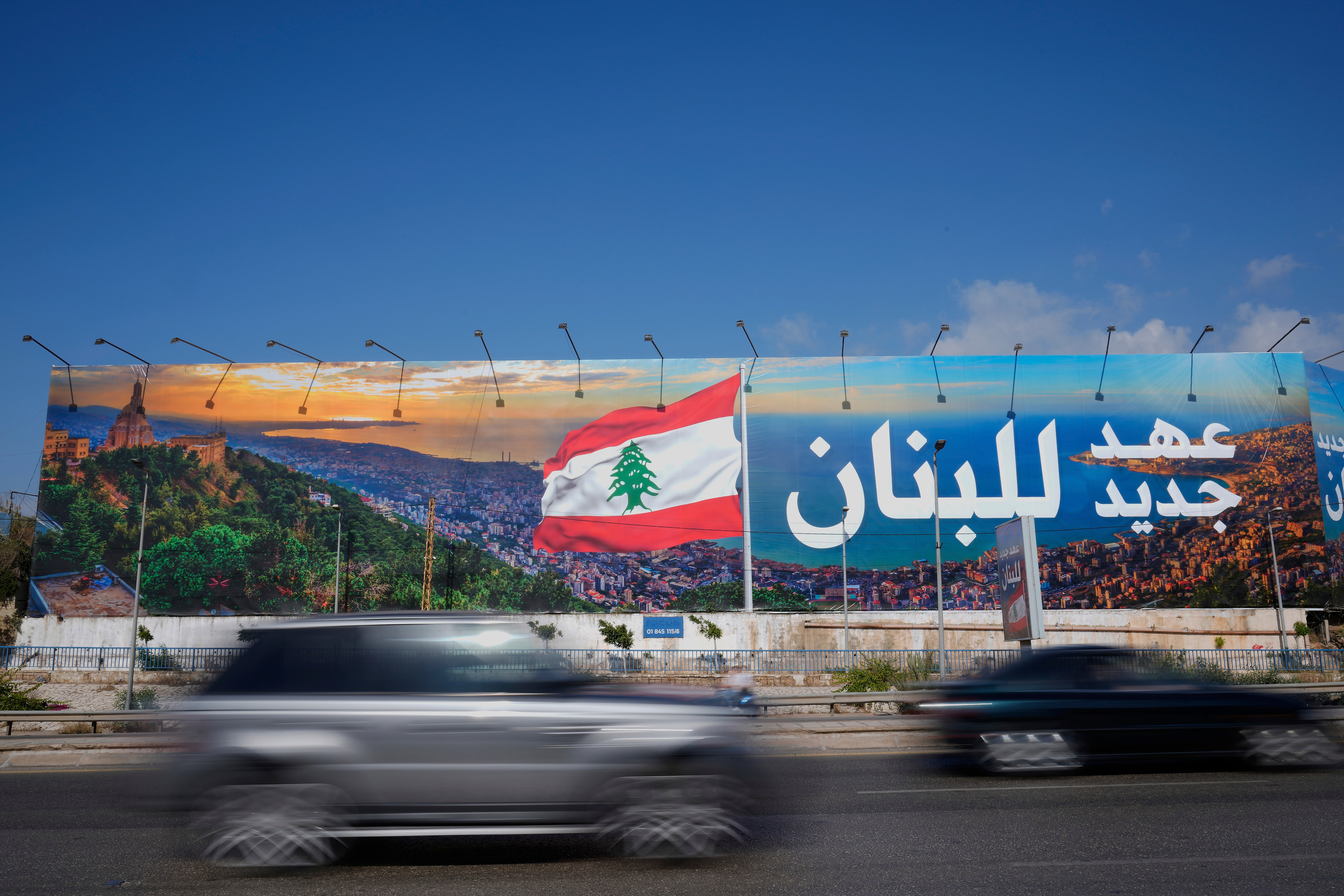 Cars pass in front of a billboard that reads, in Arabic, "A new era for Lebanon," in Beirut, Lebanon, May 28, 2025. (AP Photo/Hussein Malla)