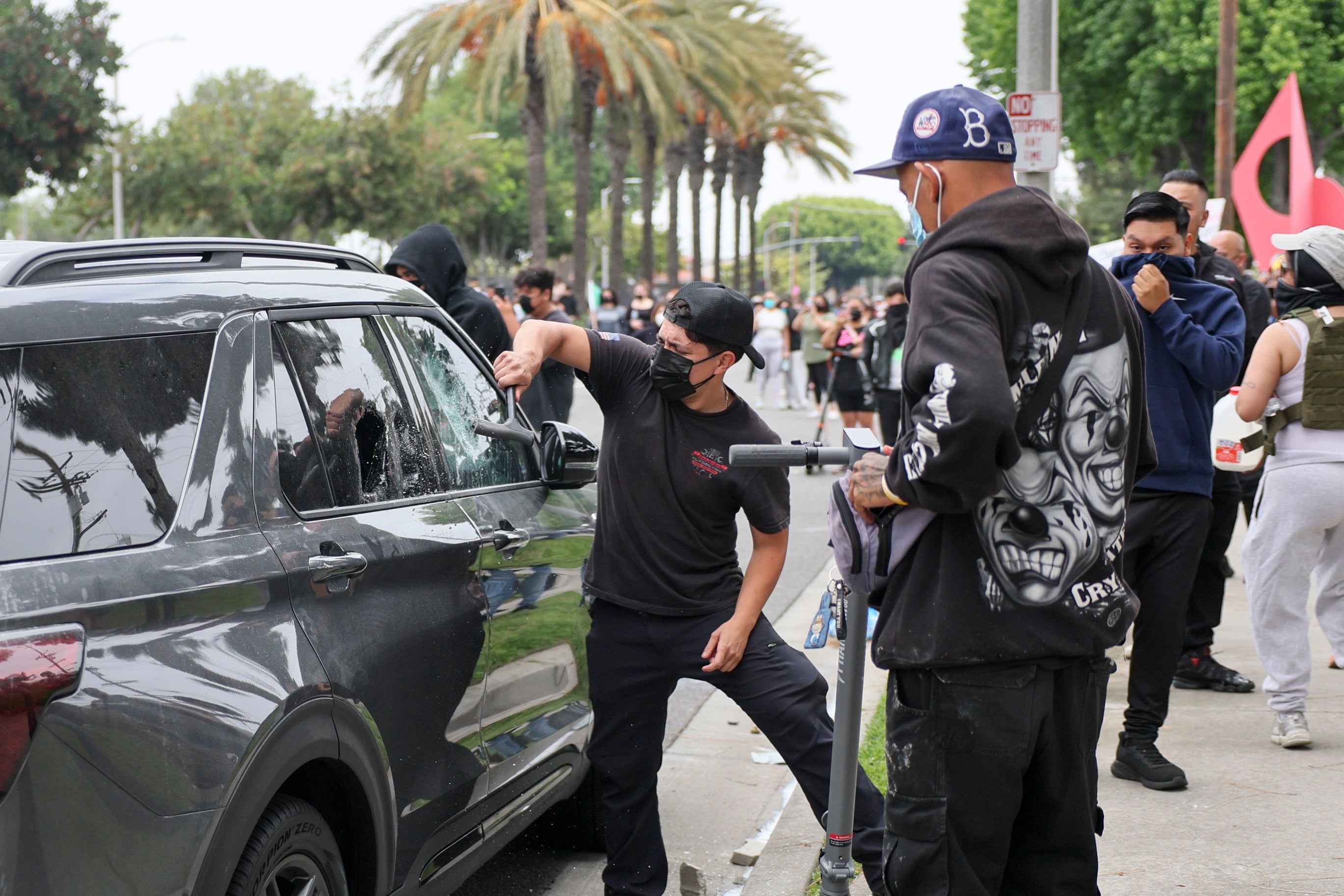 Protesters smashing open a car