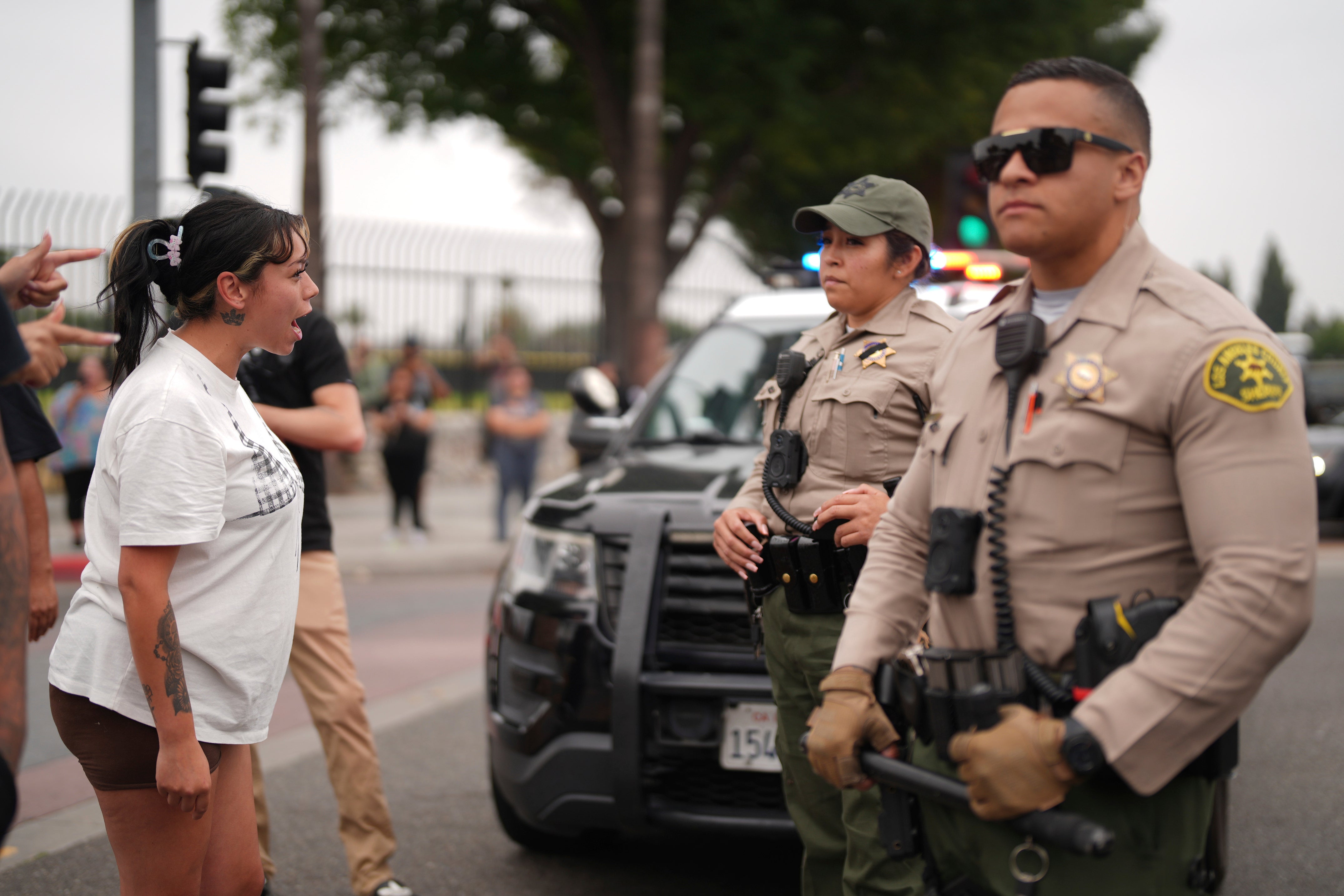 A protester remonstrates with law enforcement outside an industrial park in Paramount