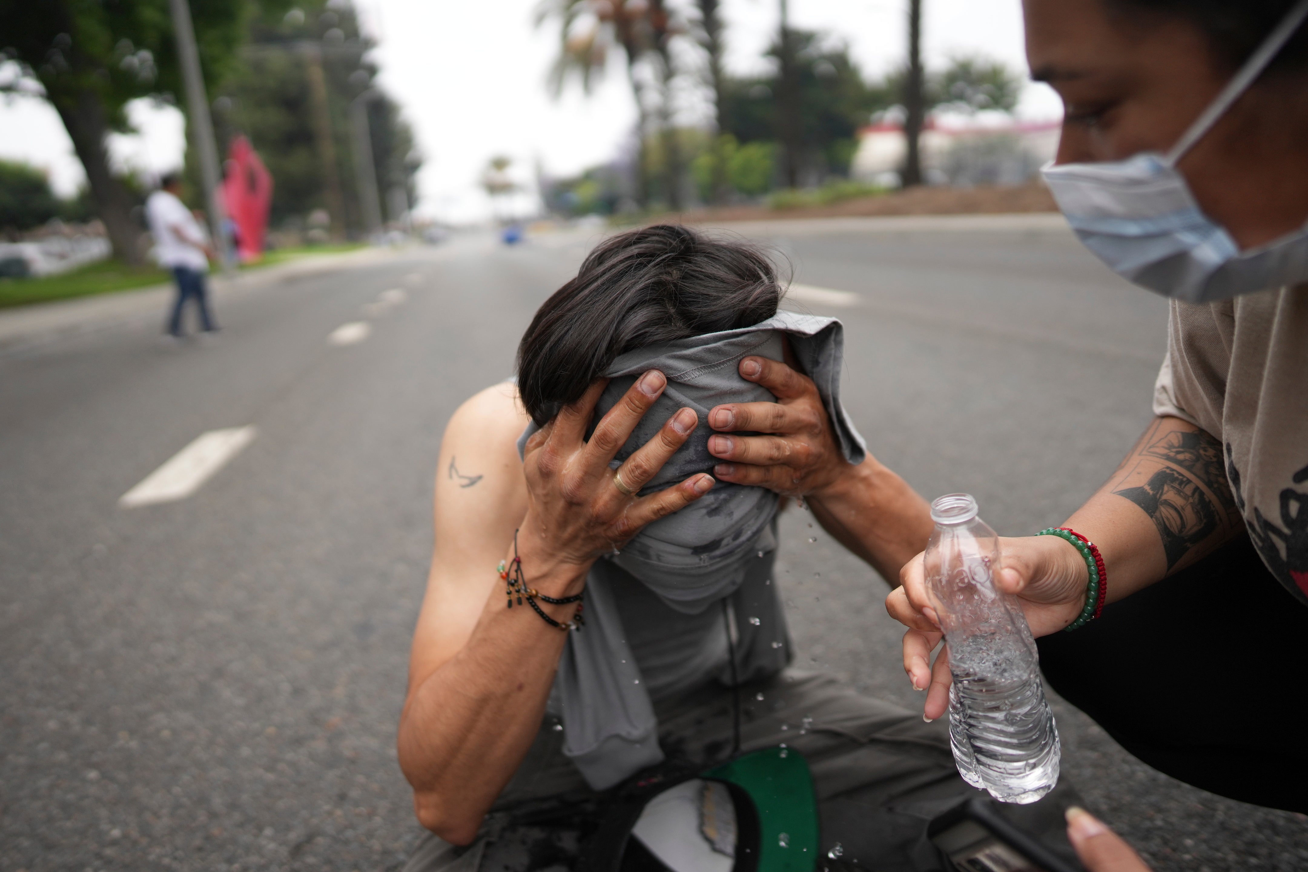 A protester is given aid after police reportedly fired tear gas