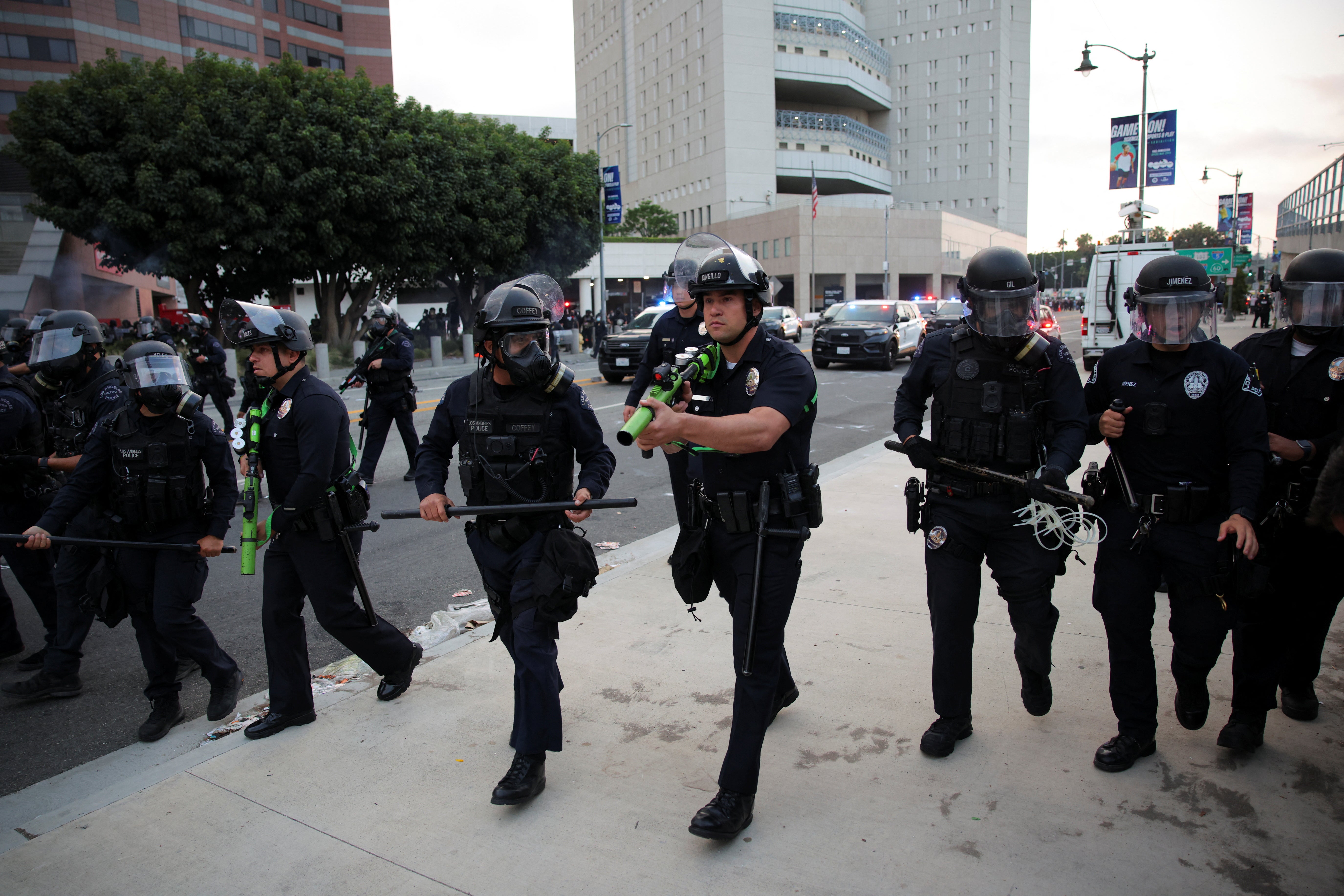 Police take positions as they clash with protesters gathered around the Los Angeles Federal Building following multiple detentions by Immigration and Customs Enforcement (ICE), in downtown Los Angeles, California