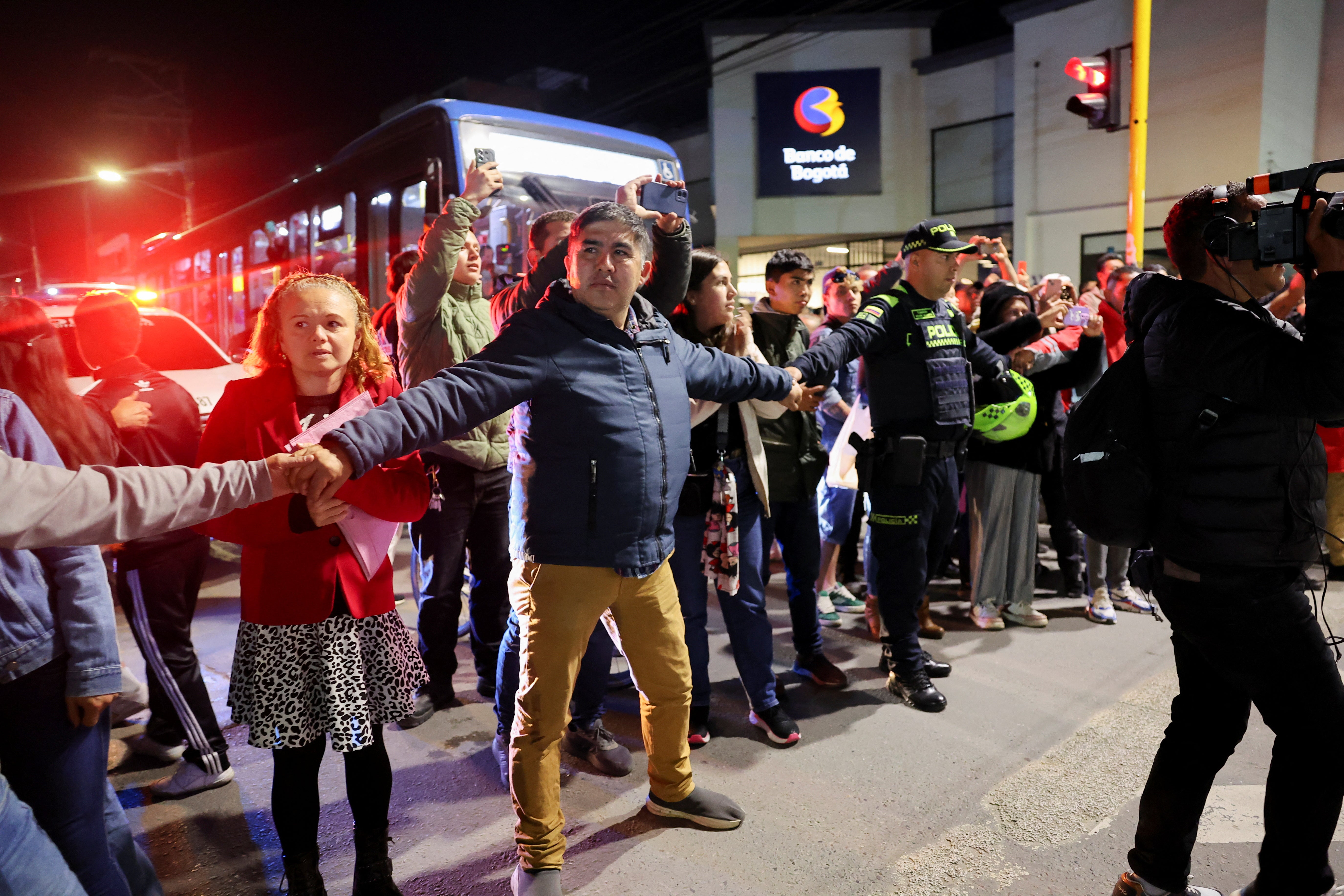 People make way for an ambulance carrying Uribe to a hospital following his shooting
