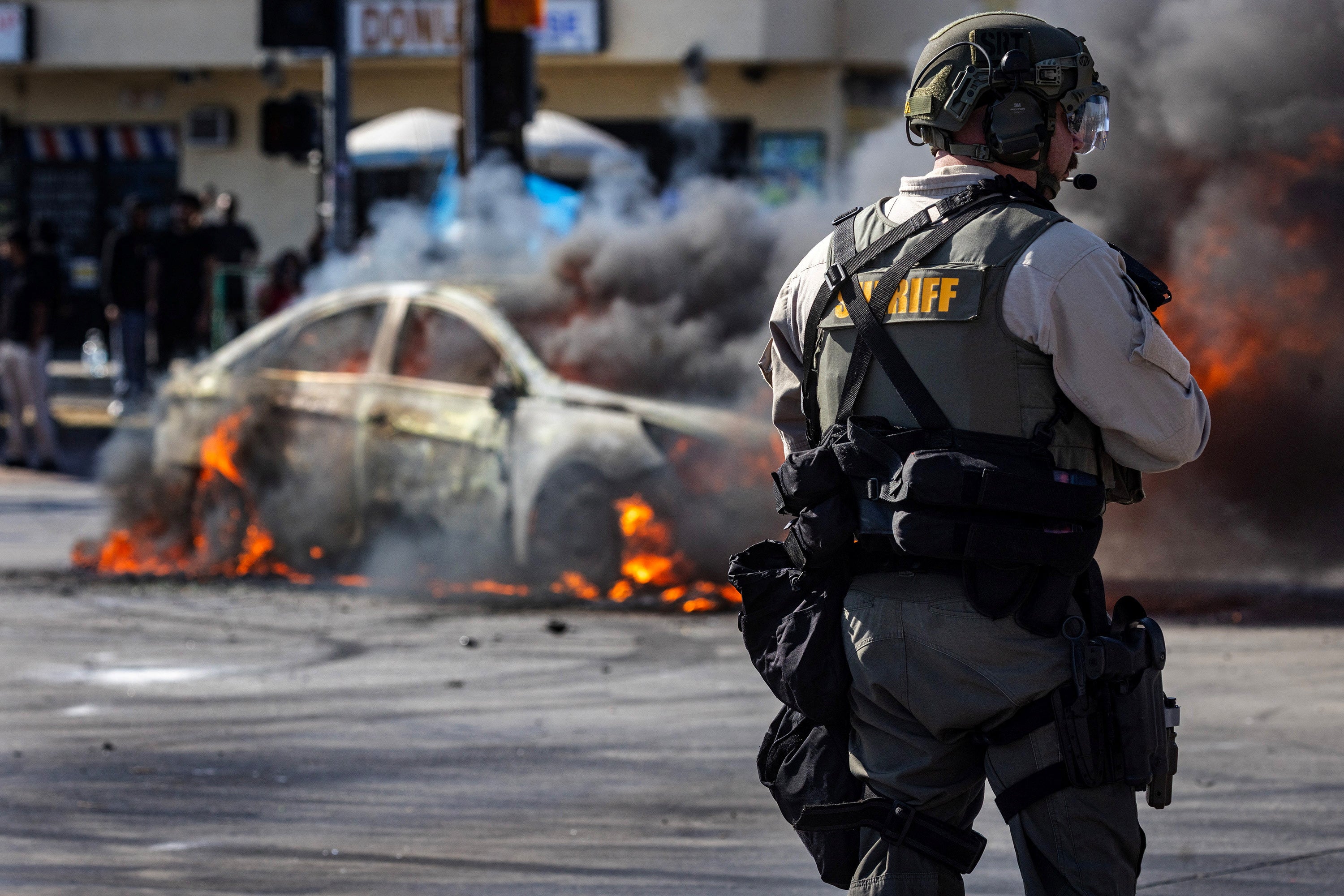 Smoke rises from a burning car on Atlantic Boulevard during a standoff by protesters and law enforcement, LA, California, US, June 7, 2025