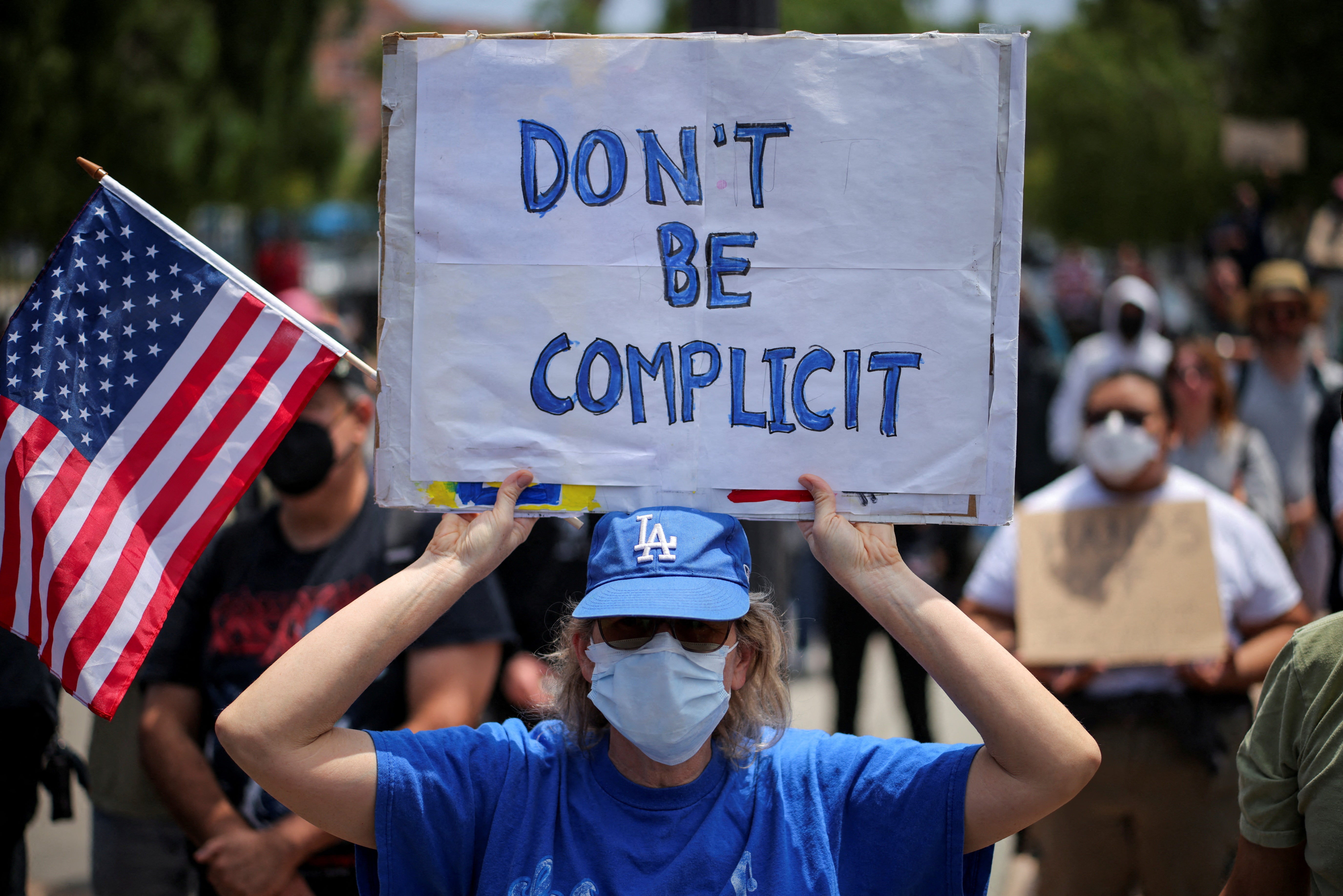 A demonstrator holds a placard at a protest against federal immigration sweeps in the Boyle Heights neighborhood of Los Angeles, California, U.S. June 8, 2025