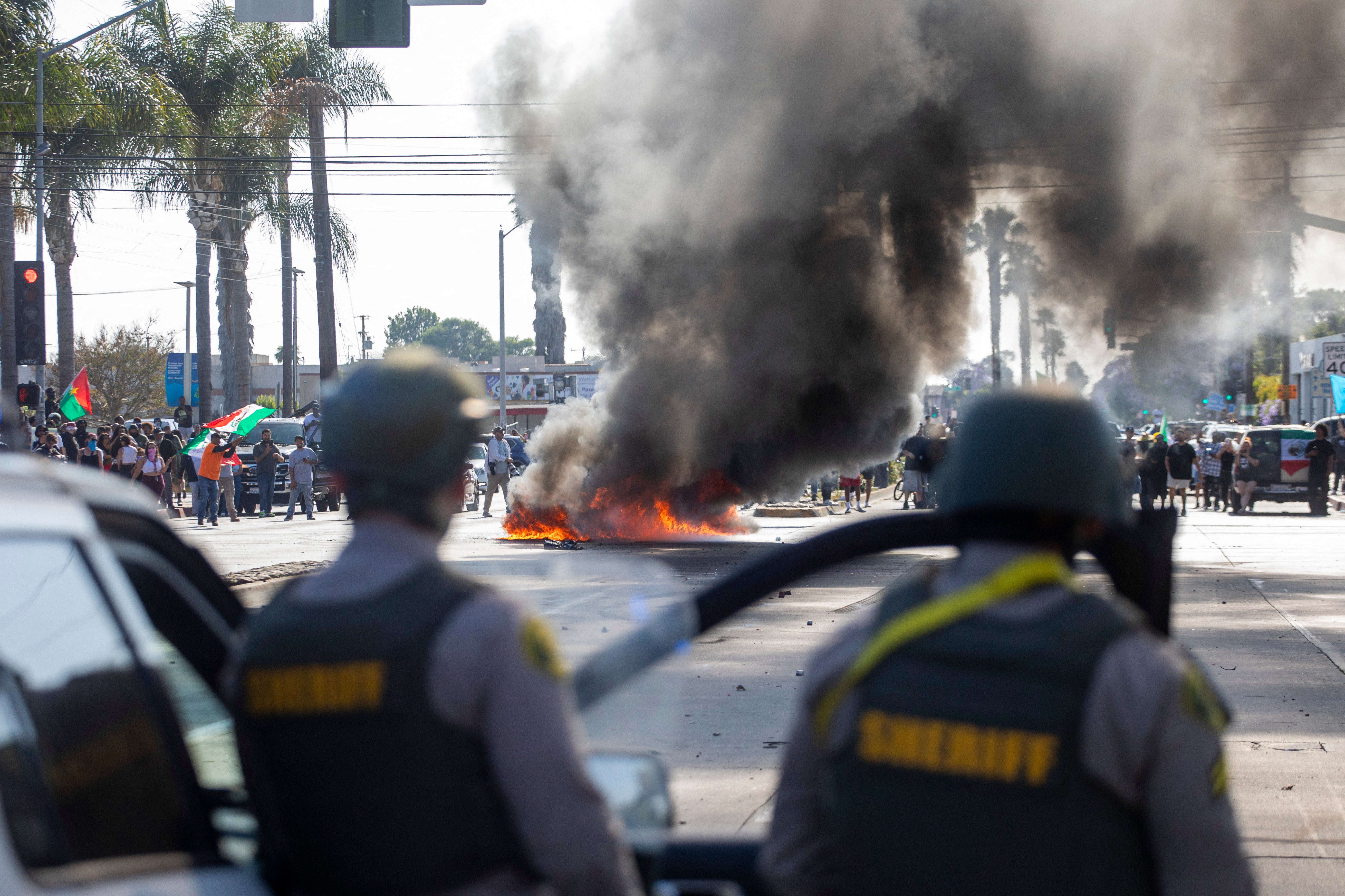 A car burns as law enforcement clashes with demonstrators during a protest following federal immigration operations, in the Compton neighborhood of Los Angeles, California on June 7, 2025