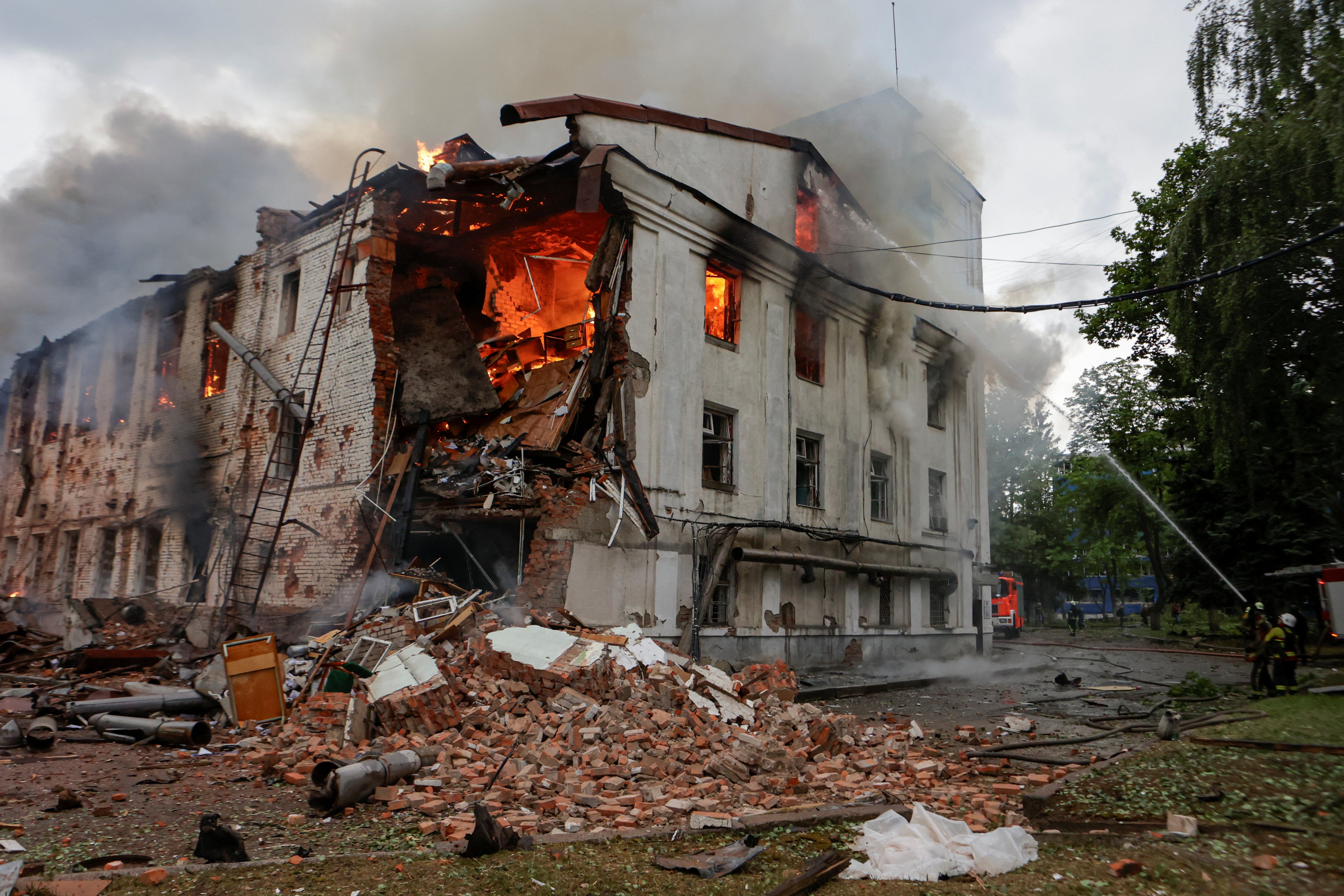 Firefighters work at the site of a building hit by a Russian drone strike in Kharkiv
