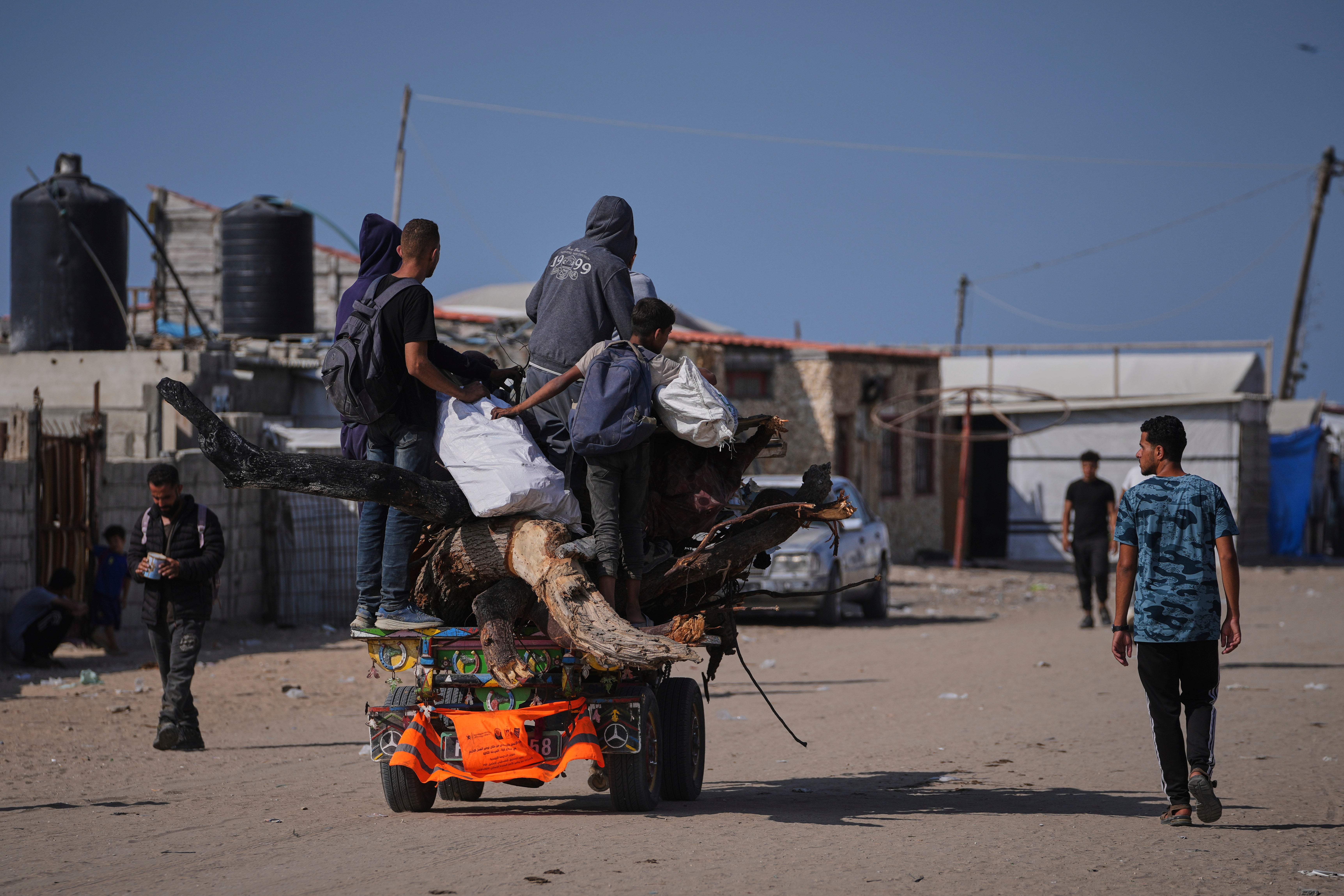 Displaced Palestinians carry wood and other items in Rafah