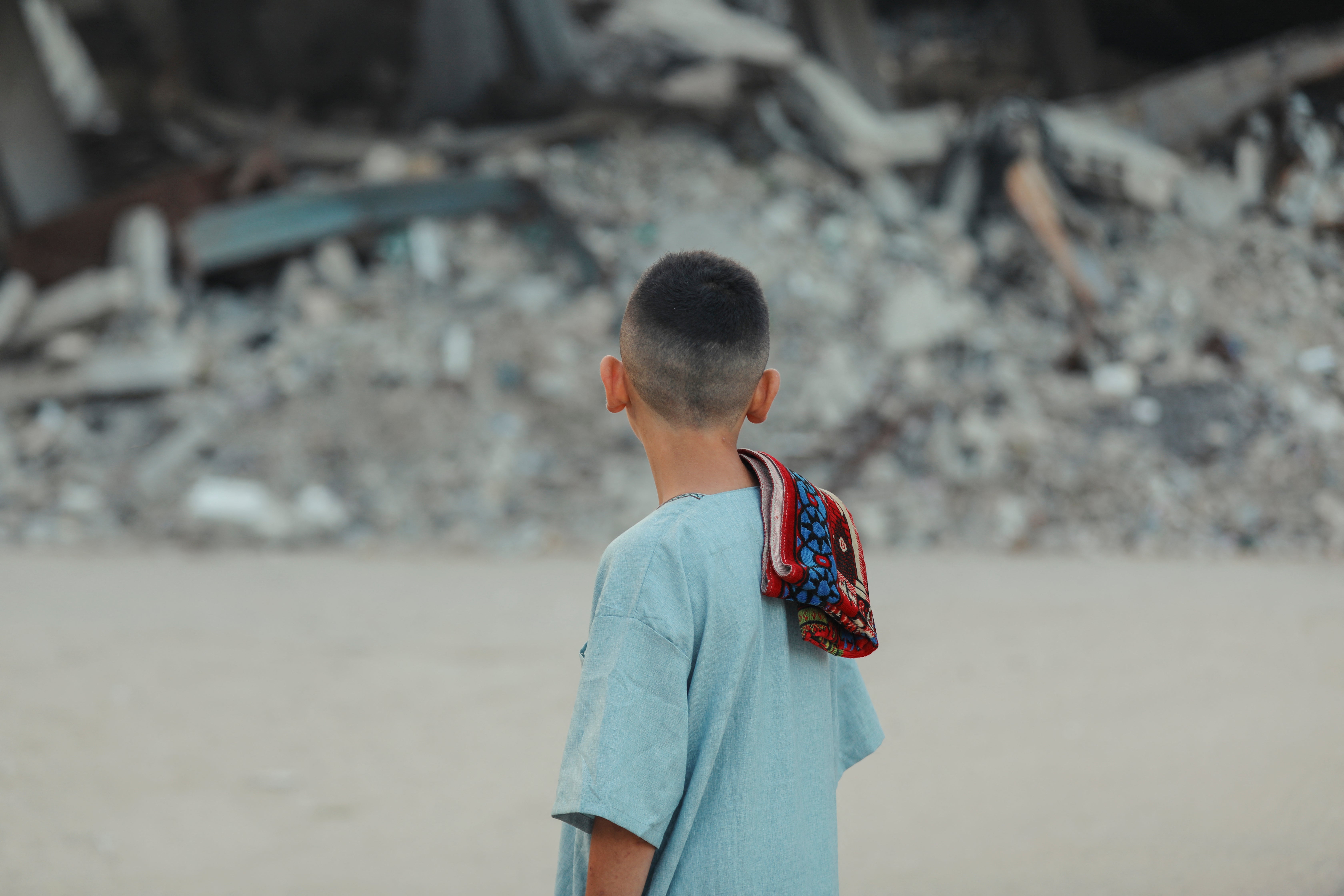 A Palestinian boy walks to perform Eid prayers amid the rubble of destroyed buildings in Gaza