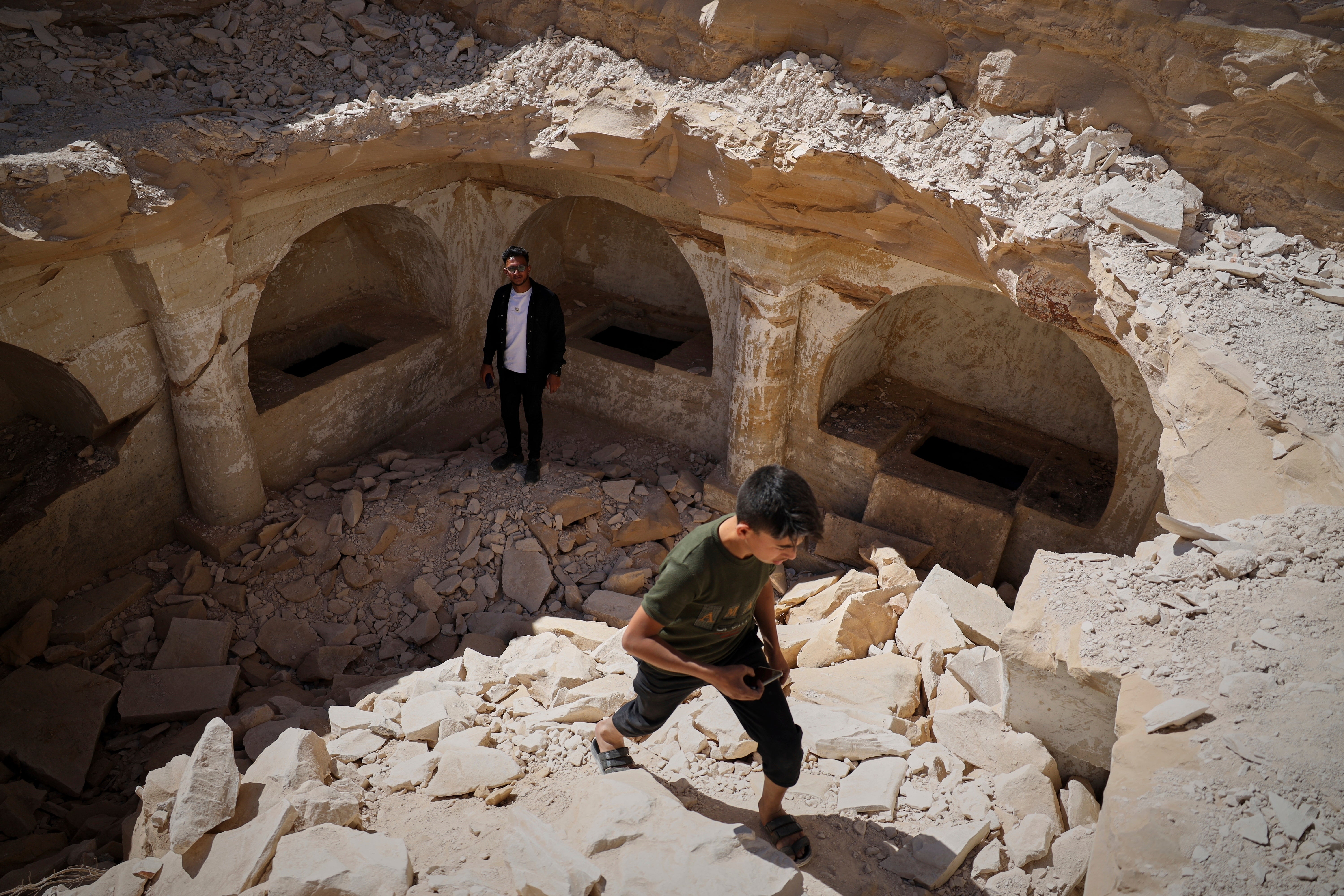 A boy walks out of a pit after exploring the tombs from a Byzantine underground complex. (AP Photo/Omar Albam)