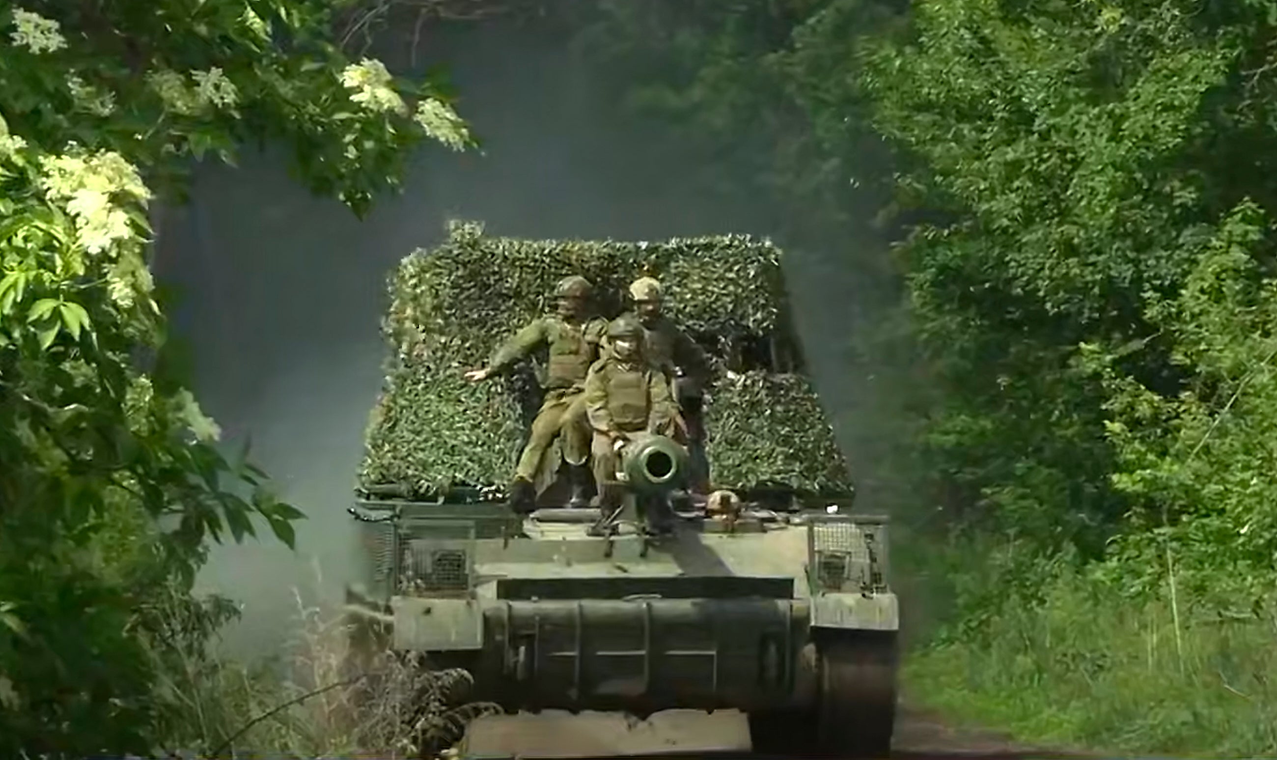 Russian soldiers ride an Akatsiya self-propelled gun in an undisclosed location in Ukraine