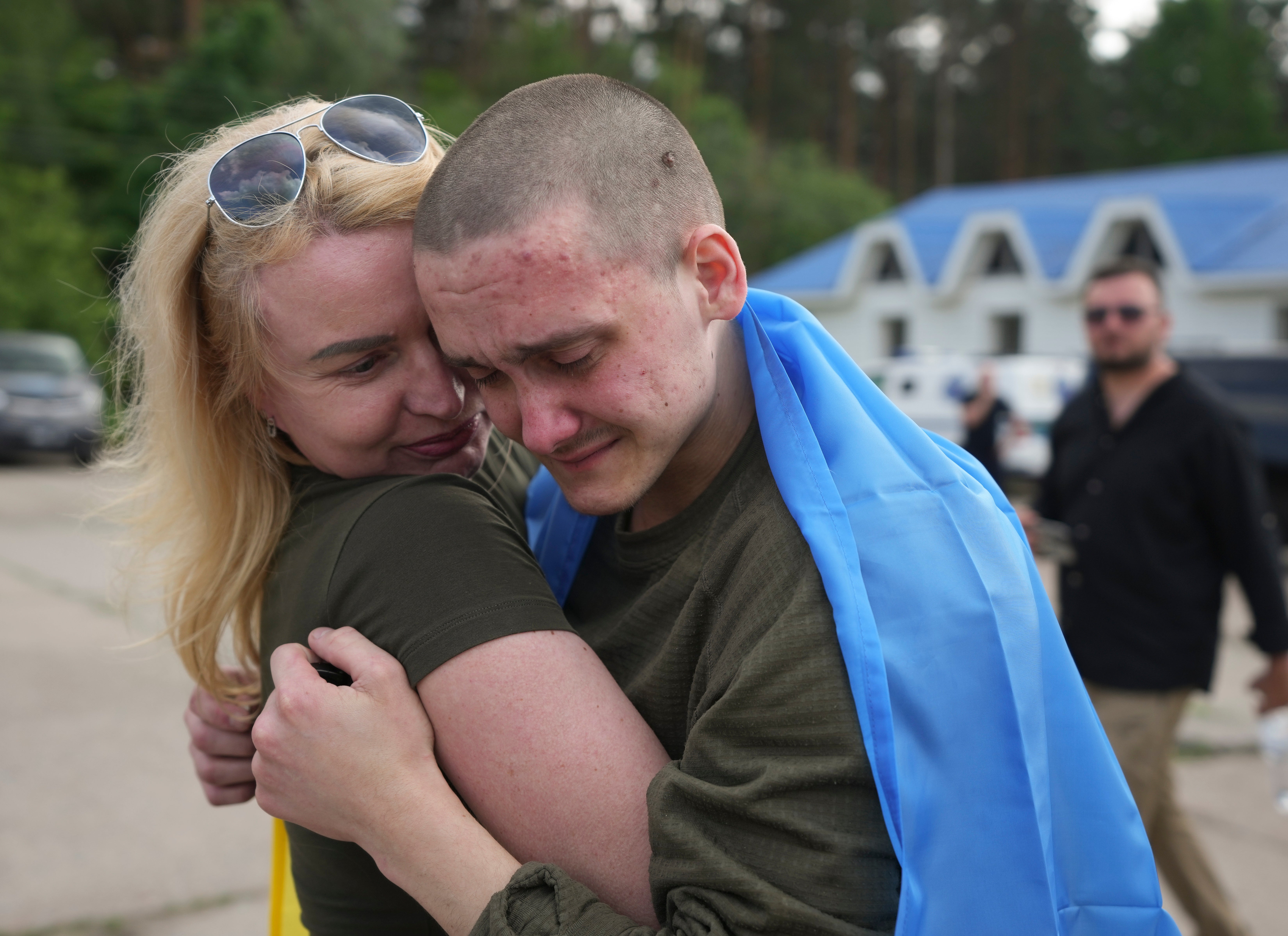 Ukrainian prisoners of war hug following a prisoner swap with Russia