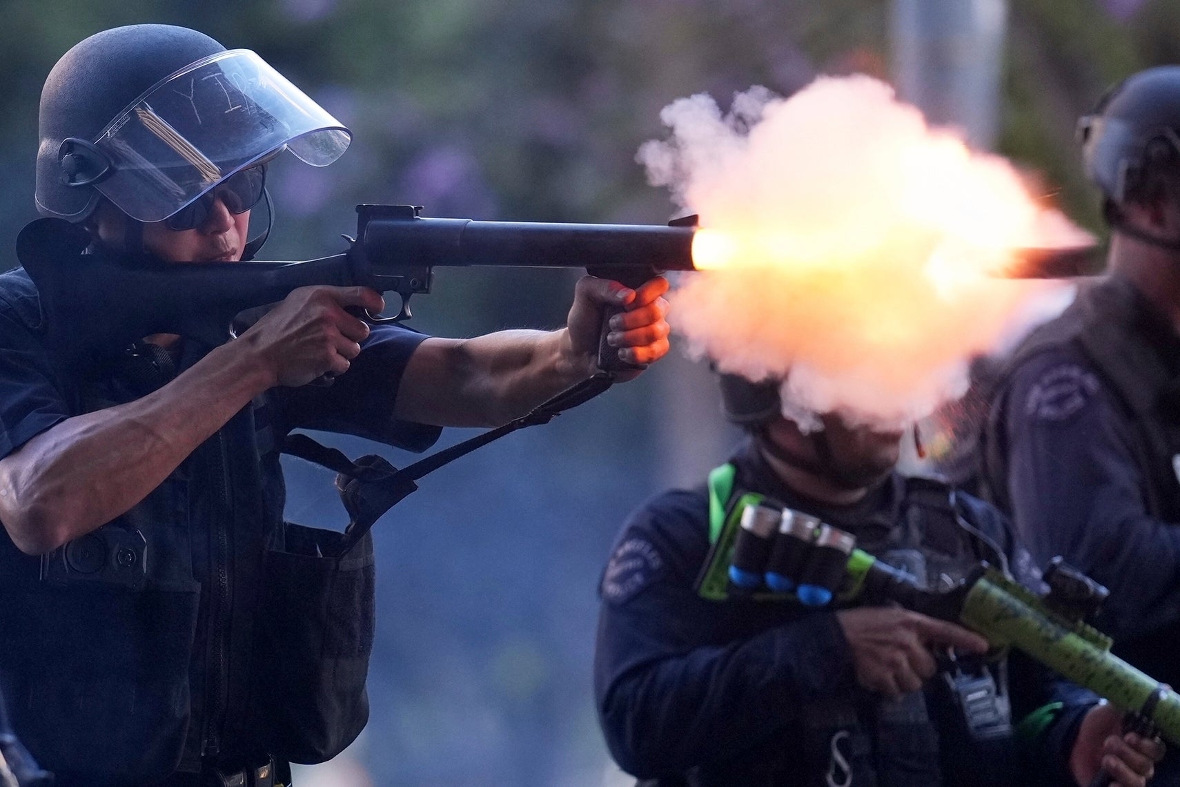 A police officer fires soft rounds in Los Angeles on Sunday night