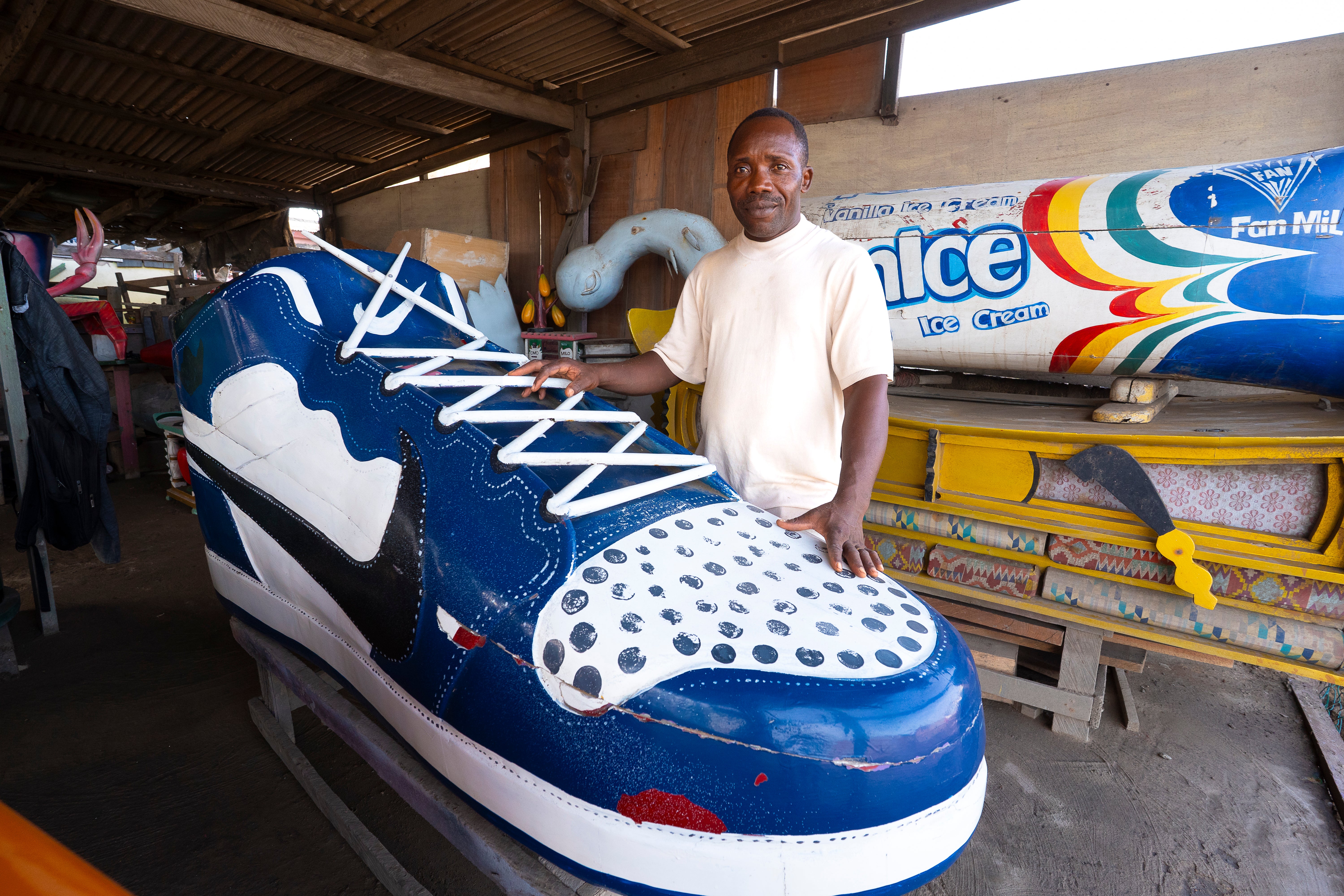 Coffin maker Eric Kpakpo Adotey stands alongside one of his unique creations