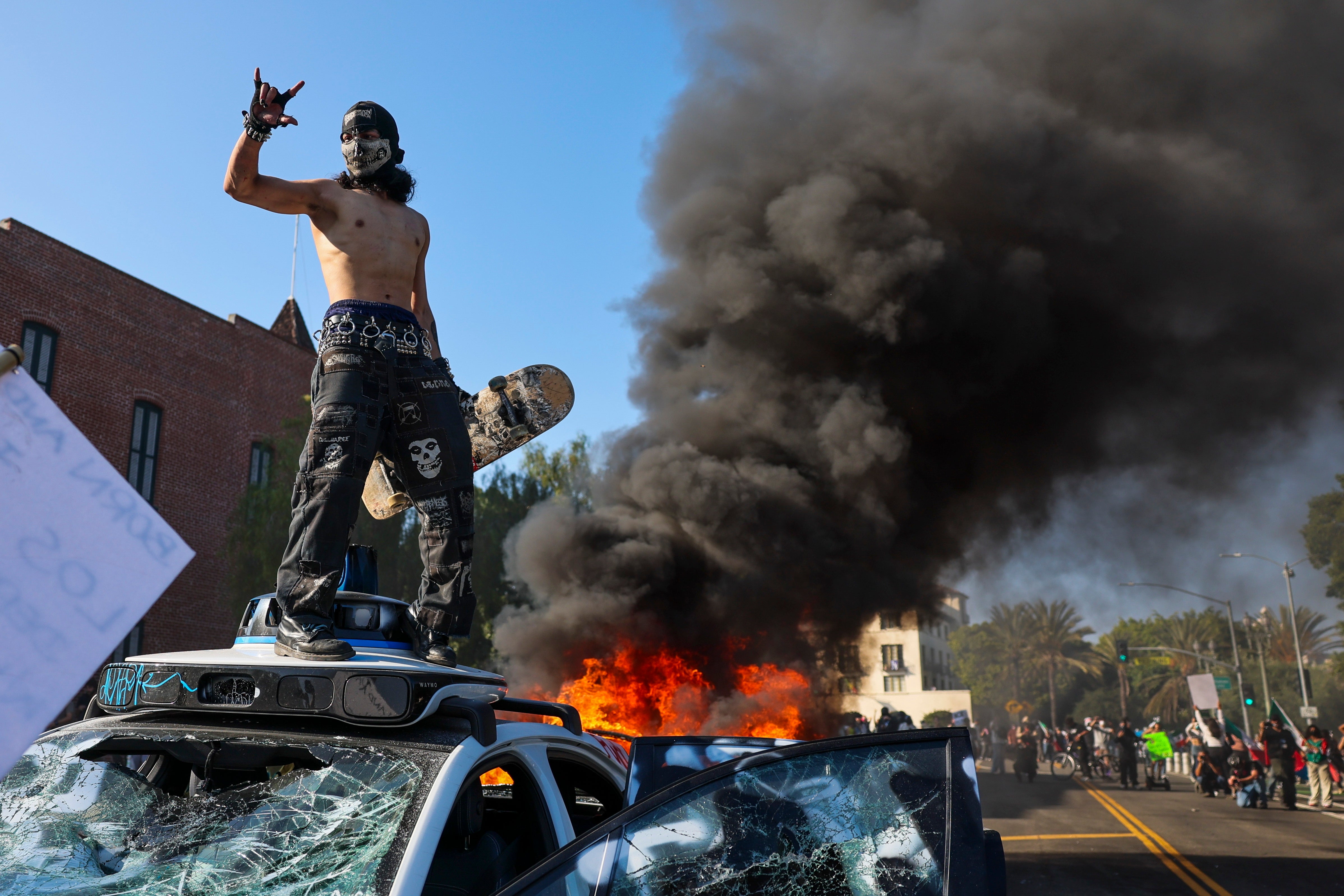 Protesters vandalize a Waymo self-driving car in Los Angeles