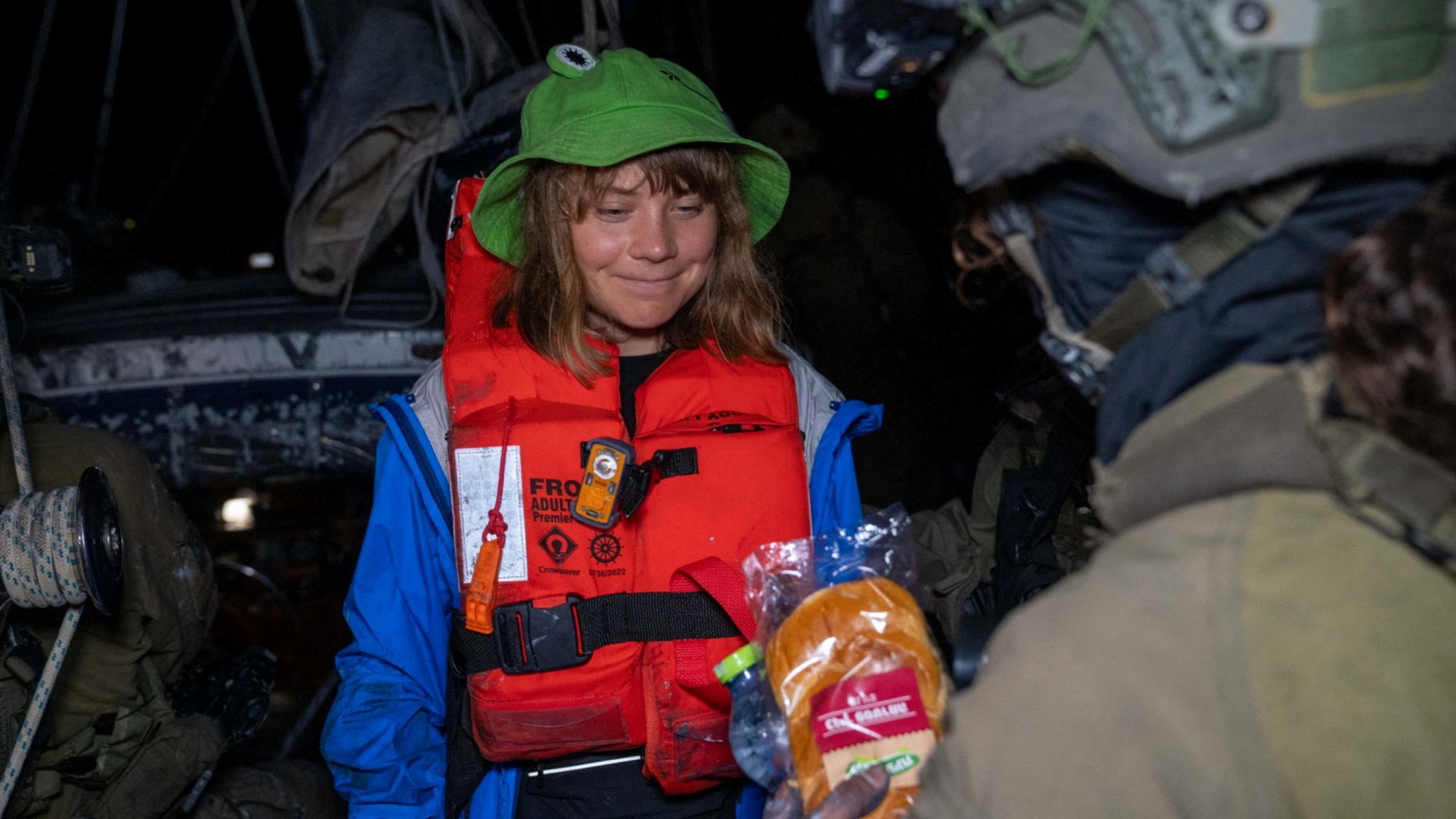 An Israeli solider passes a bun to Greta Thunberg onboard the Gaza-bound British-flagged yacht "Madleen" after Israeli forces boarded the charity vessel
