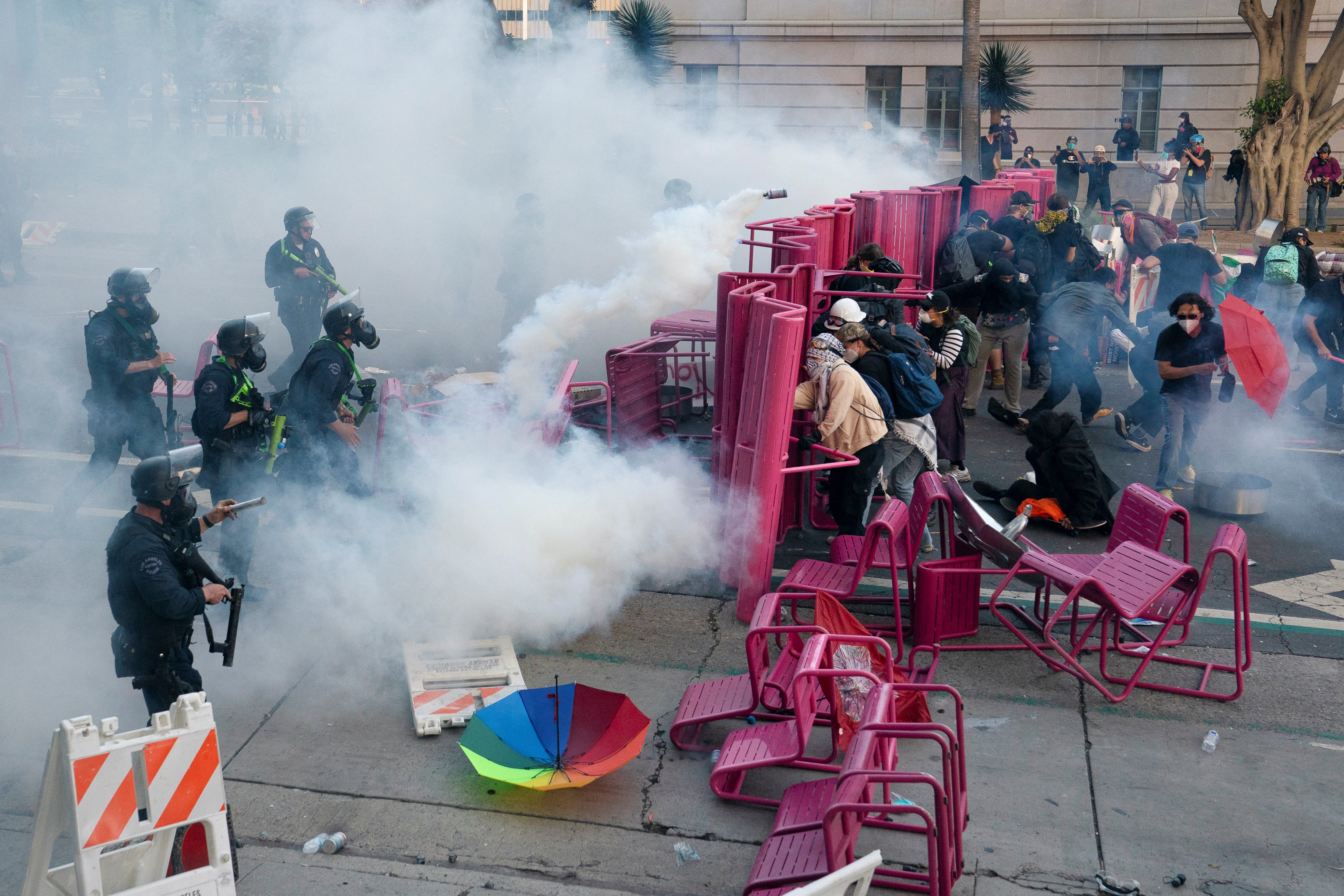 Police clear demonstrators after they blocked a street with a barricade during a protest against federal immigration sweeps in downtown Los Angeles.