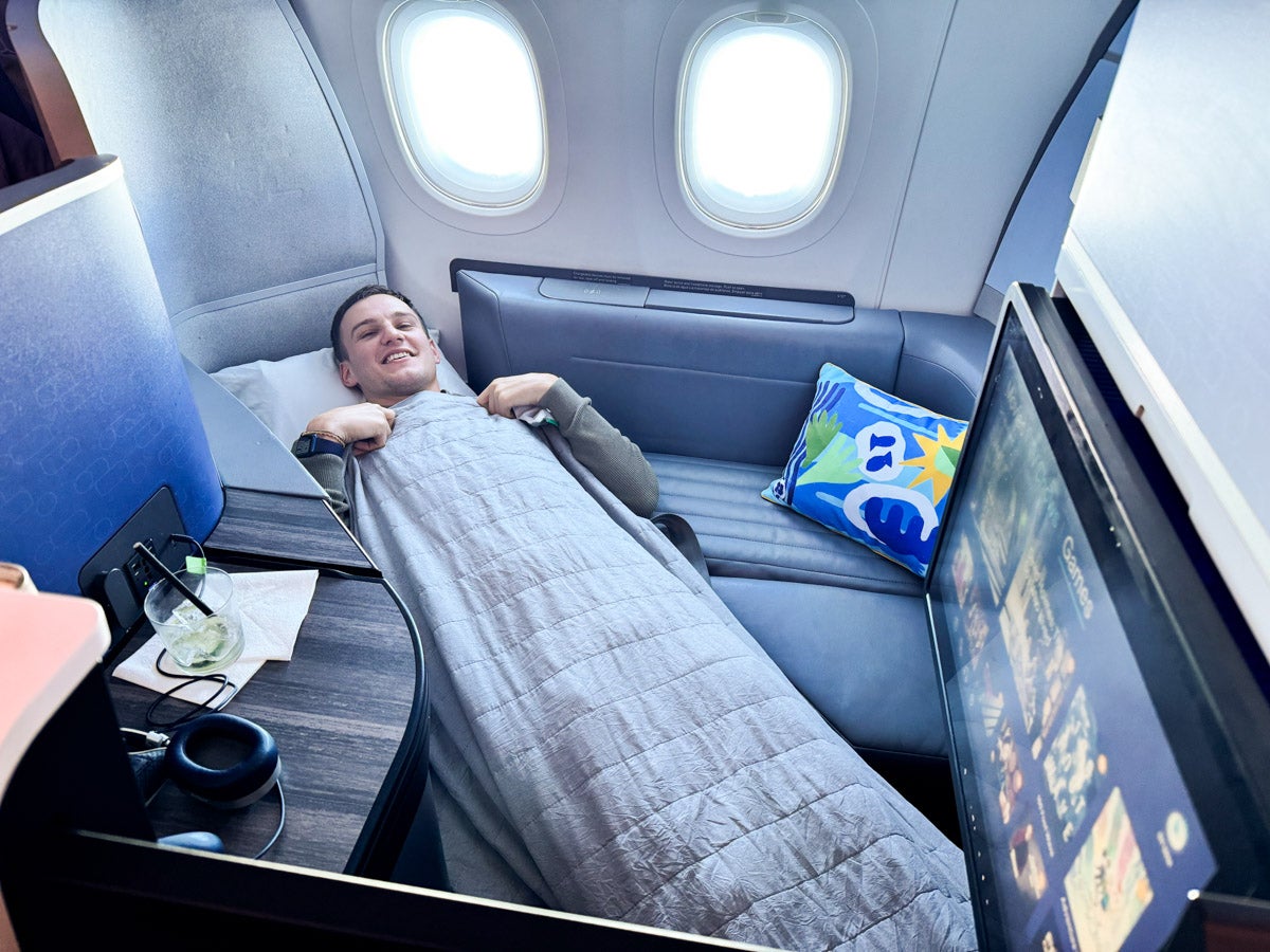 Dream job: Rhys declares that he could not perform his role as an aviation writer by flying economy. He's pictured here on a JetBlue Airbus A321LR from London to Boston