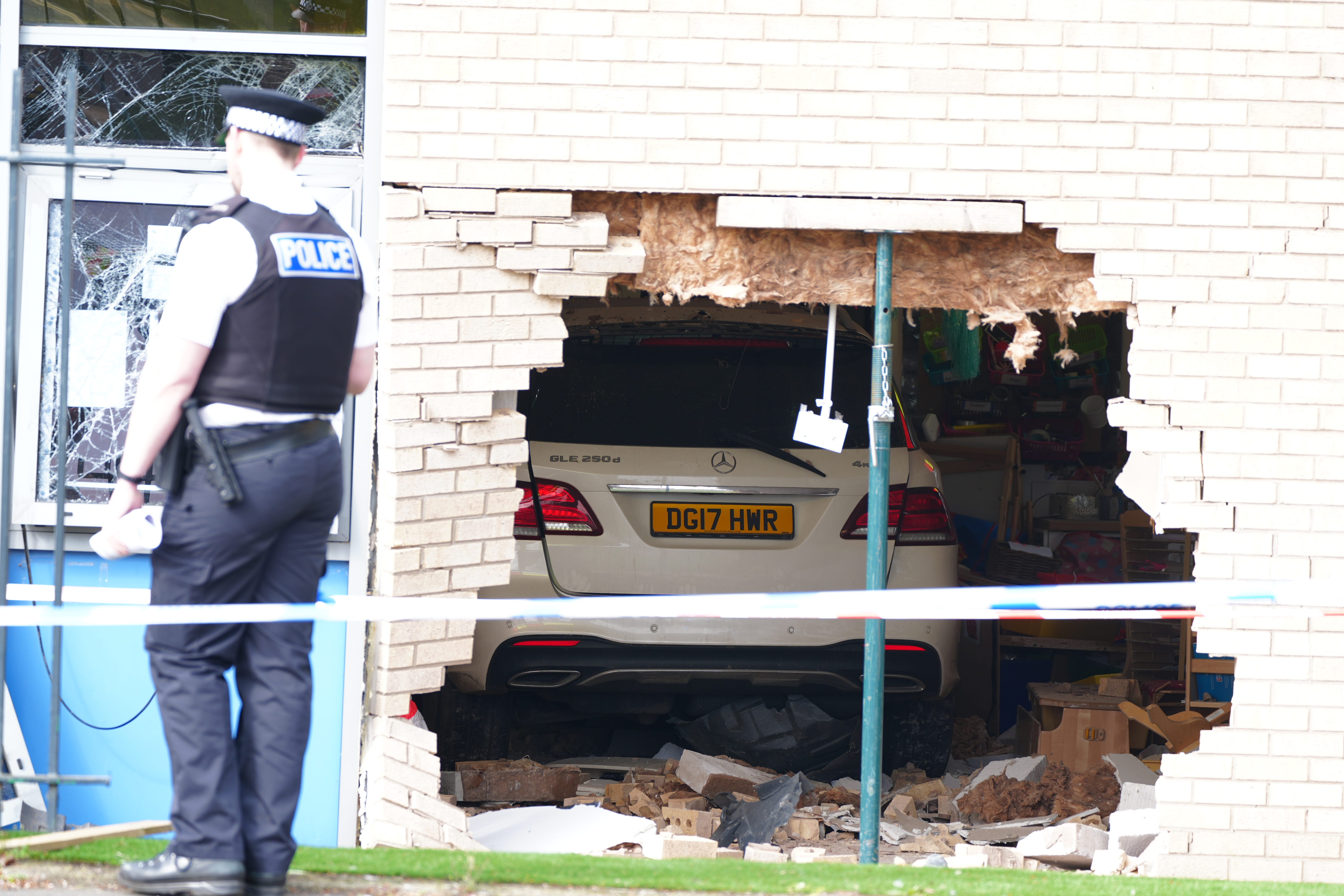 Police officers stand beside the debris and damage to the Beacon Church of England Primary School, in Everton, Liverpool, after a car crashed into the building (Peter Byrne/PA)