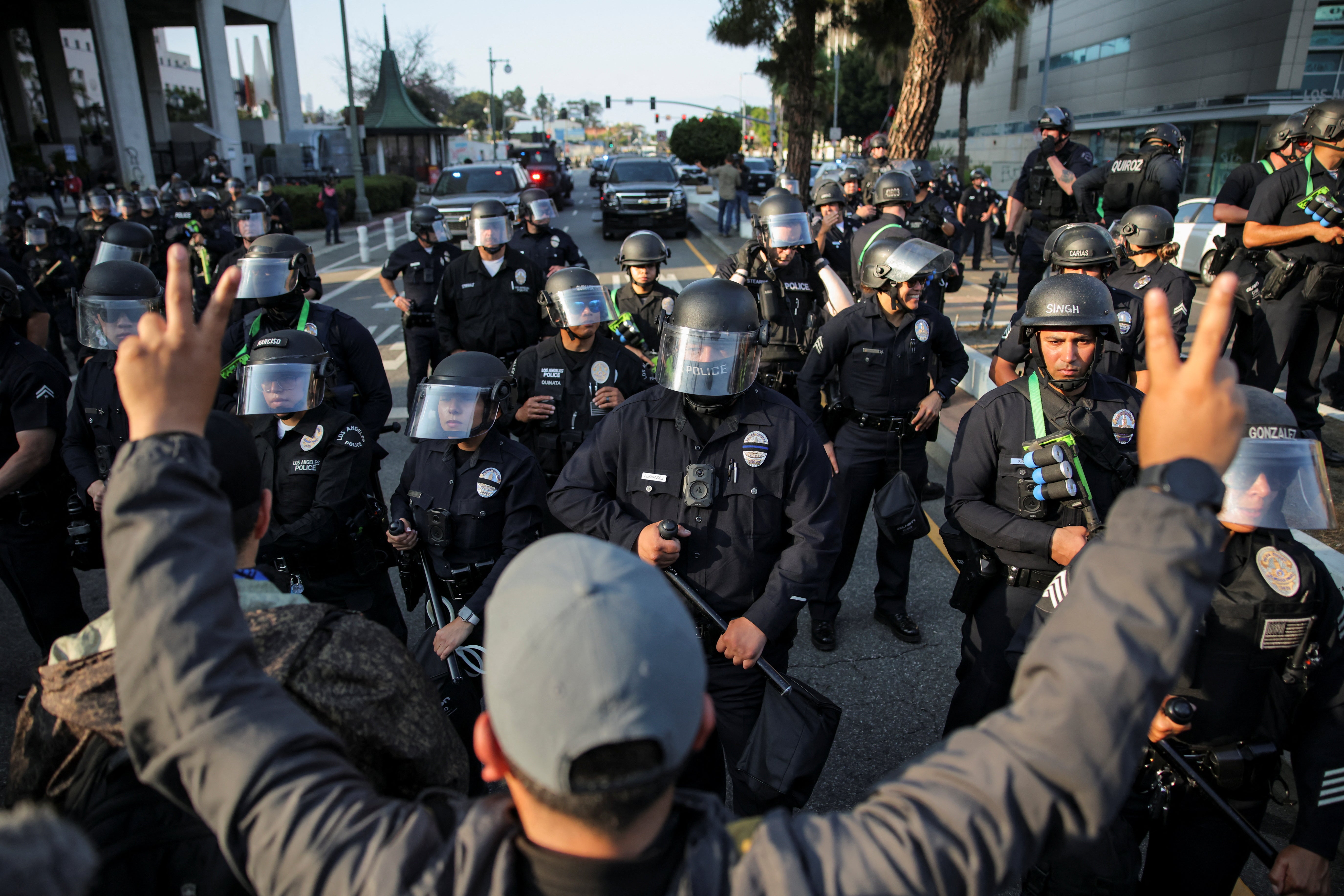 A protester gestures in front of members of law enforcement who are standing guard, as protests against federal immigration sweeps continue, in Los Angeles, California, U.S. June 9, 2025