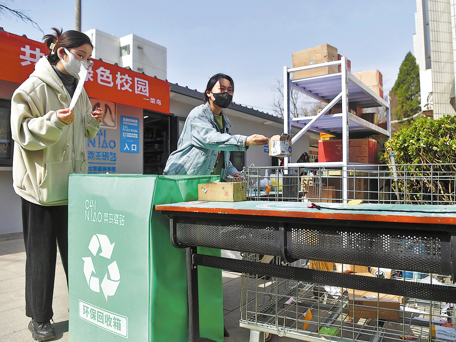 Students put packaging boxes away for recycling after use at a service station at the Beijing Institute of Fashion Technology