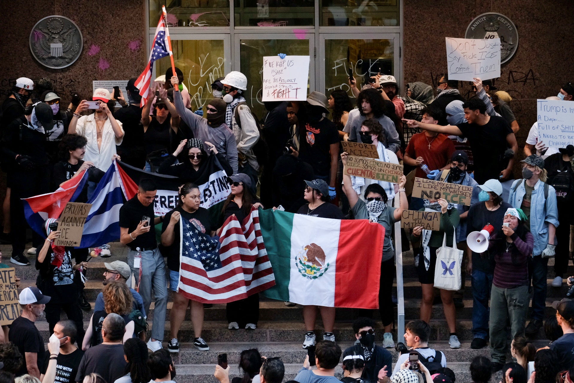 Protesters stand near a vandalized federal building in Austin, Texas