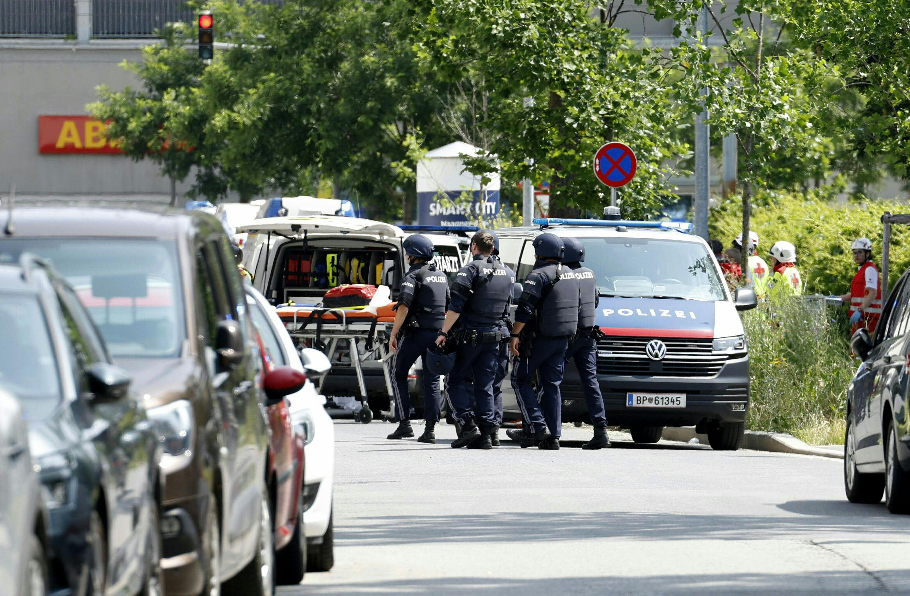 Police officers are seen in a street close to a school where, according to reports, several people died in a shooting