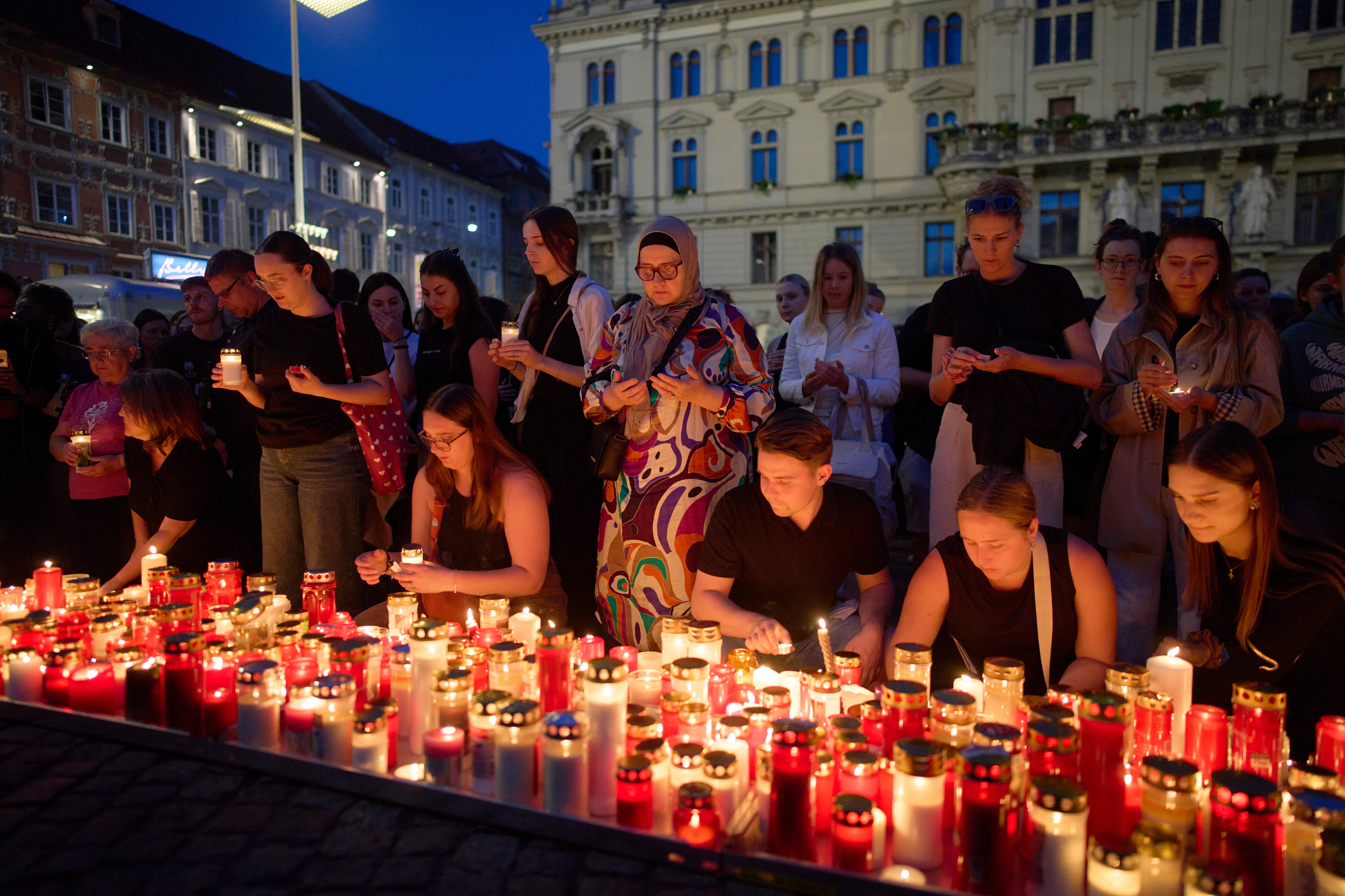 People light candles for victims of a former student who opened fire at a school, fatally wounding 10 people and injuring many others before taking his own life, in Graz, Austria