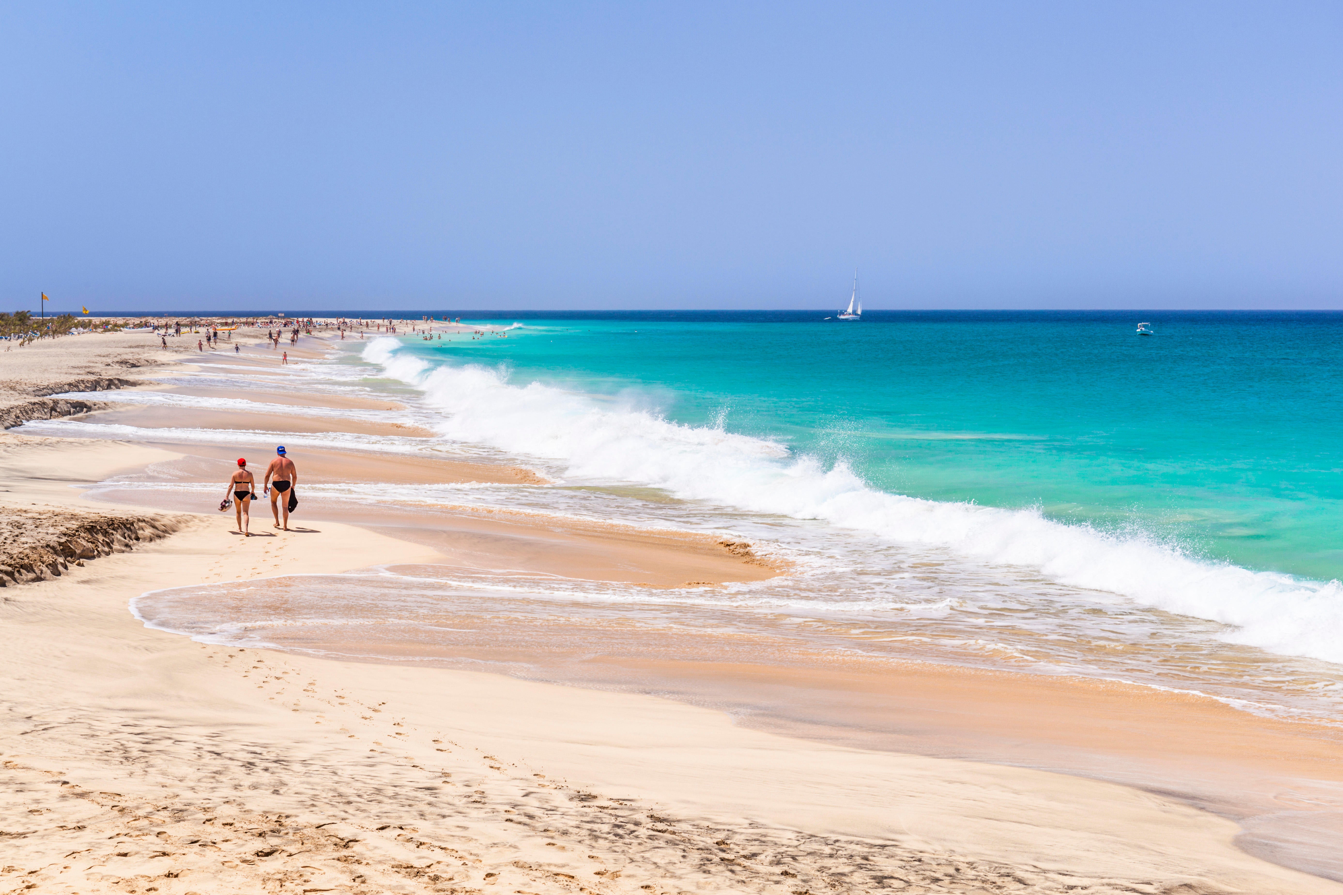 Tourists walking along a sandy beach in Cape Verde (Alamy/PA)