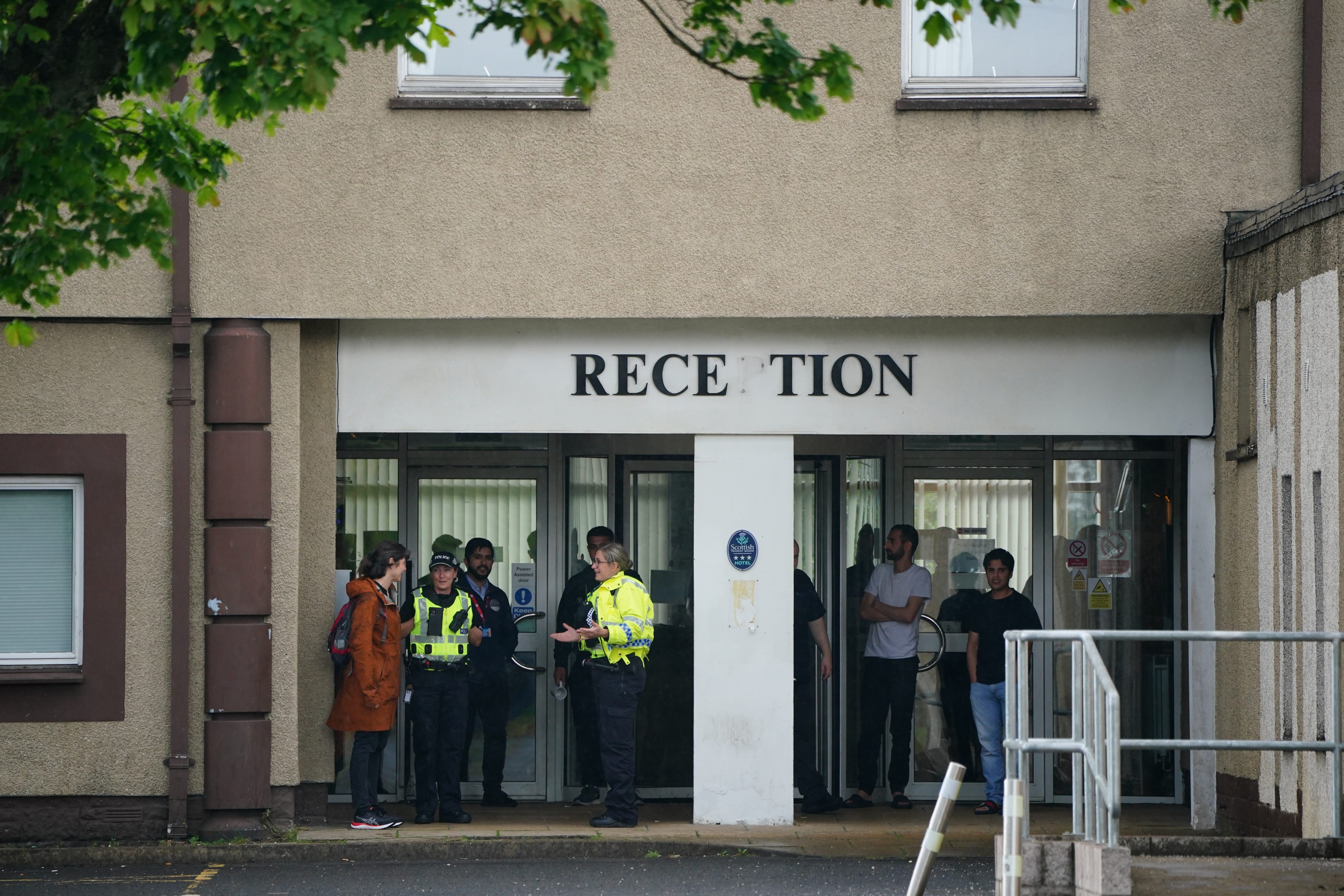 Police presence outside the Cairn Hotel in Bathgate, which was being used to house asylum seekers last year (PA)