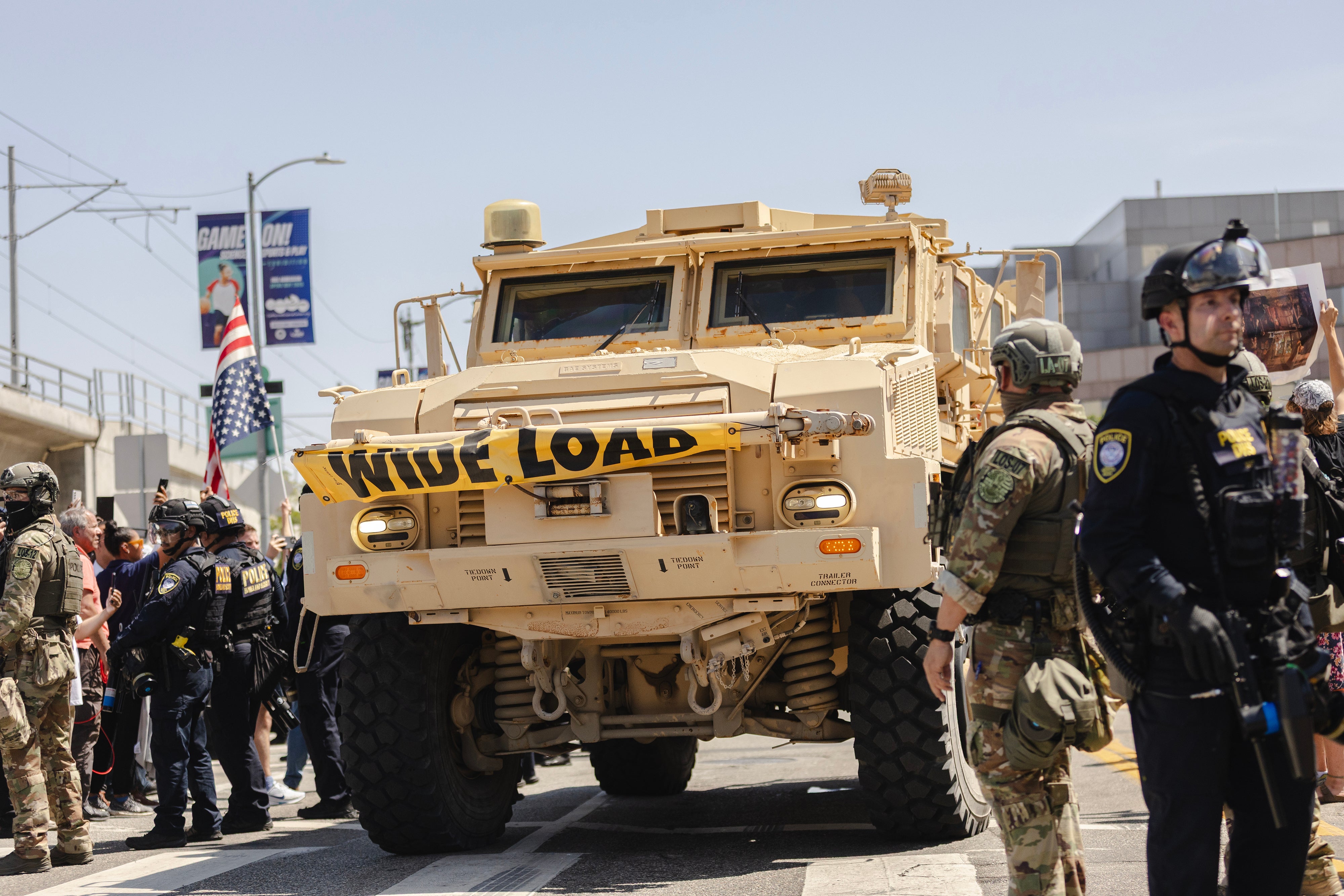 An armoured vehicle passes a police line outside of the Metropolitan Detention Center on 10 June