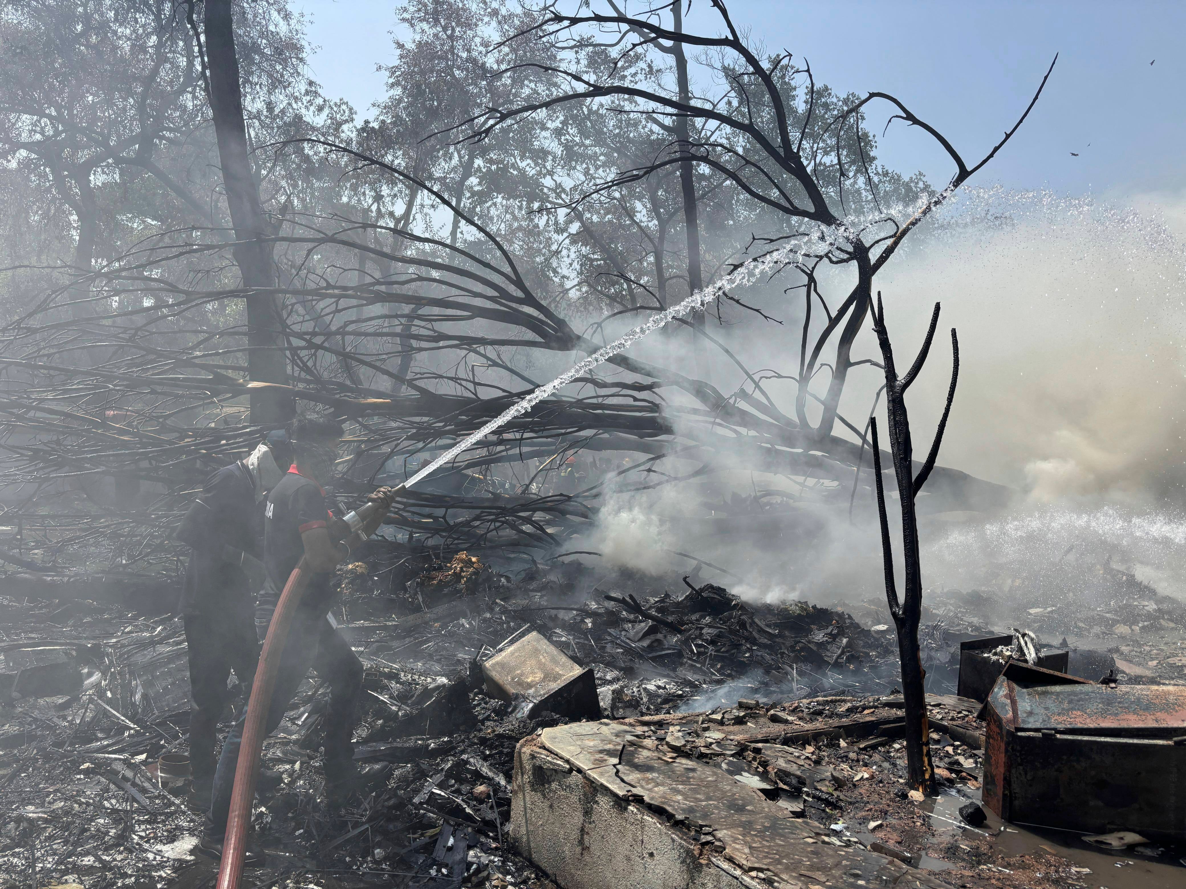 Firefighters work at the site of the plane crash